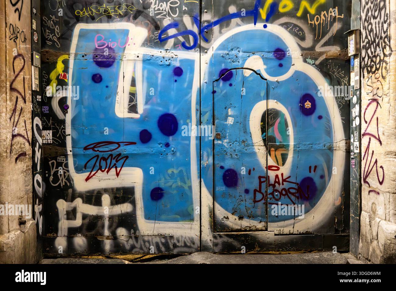Graffiti urbain et murale bleue numéro 46 sur une porte en bois à Naples. Naples, Italie - 08 janvier 2026 : un grand bleu 46 peint avec un style graffiti sur un Banque D'Images