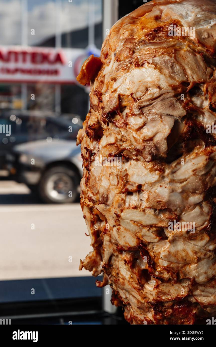 Une rôtisserie verticale fait tourner des couches de viande assaisonnée pour le shawarma. Banque D'Images