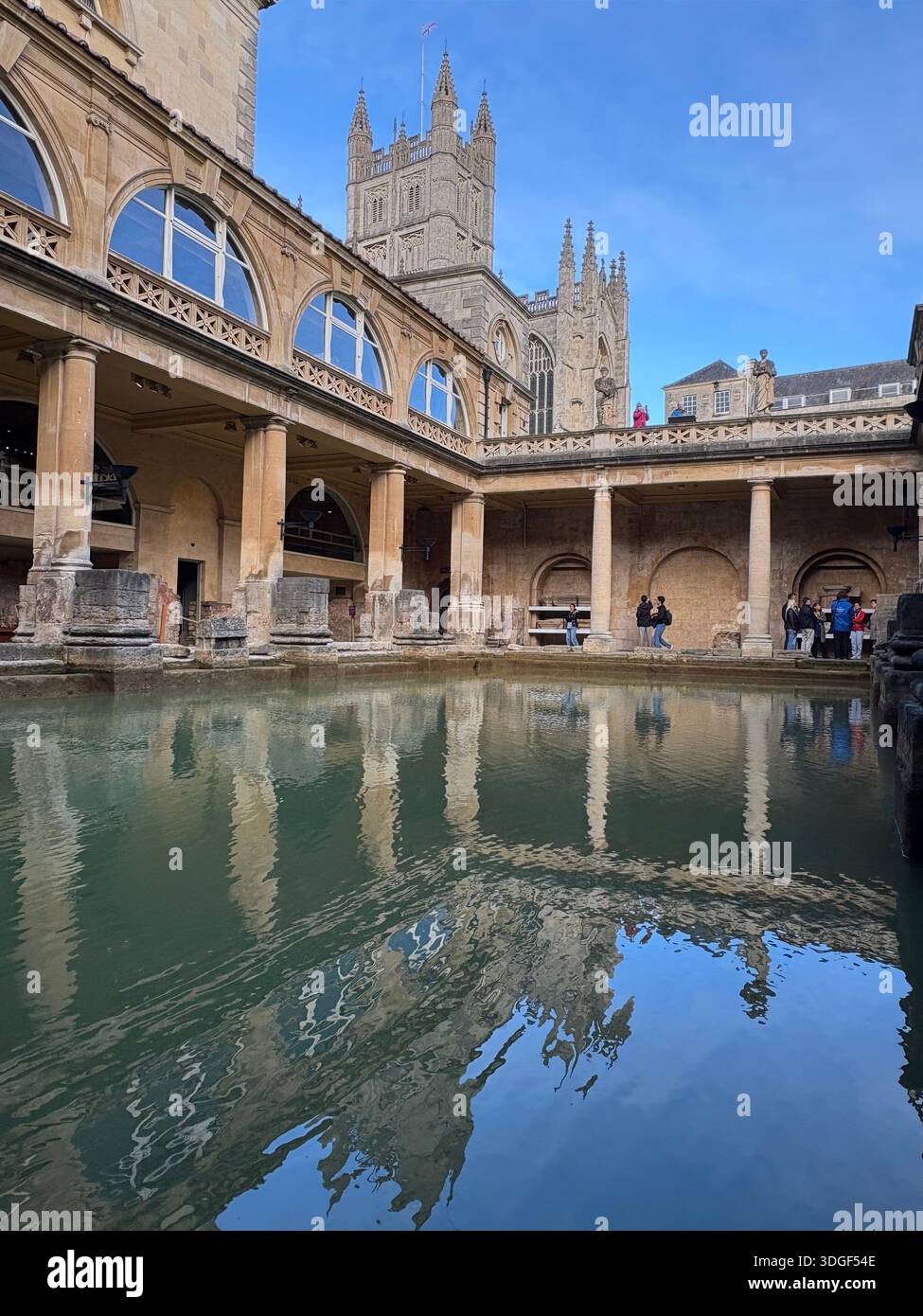 Cour des bains romains avec piscine thermale réfléchissante et architecture historique en pierre, avec l'abbaye de Bath s'élevant en arrière-plan, Angleterre. - Image de stock capturée avec un smartphone