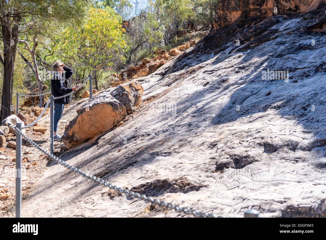 Touriste regardant des noms sculptés dans le grès à Gray Rock, Lake Dunn sculpture Trail, Queensland, Australie Banque D'Images