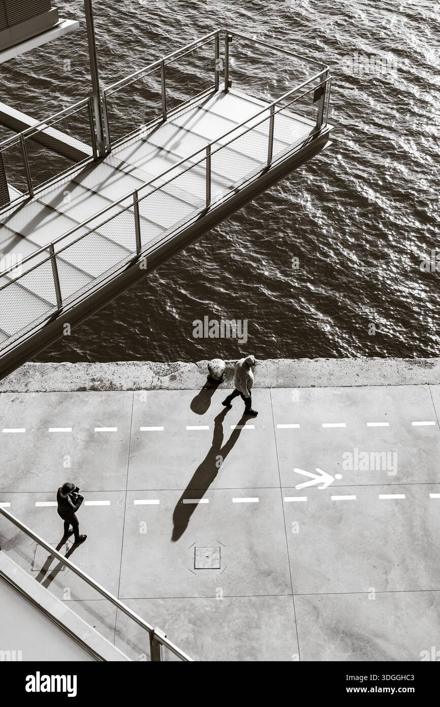Santander, Espagne – 20 novembre 2021 : vue de haut en bas noir et blanc d’une personne prenant une photo sur la promenade du front de mer avec une longue ombre projetée par le L. Banque D'Images