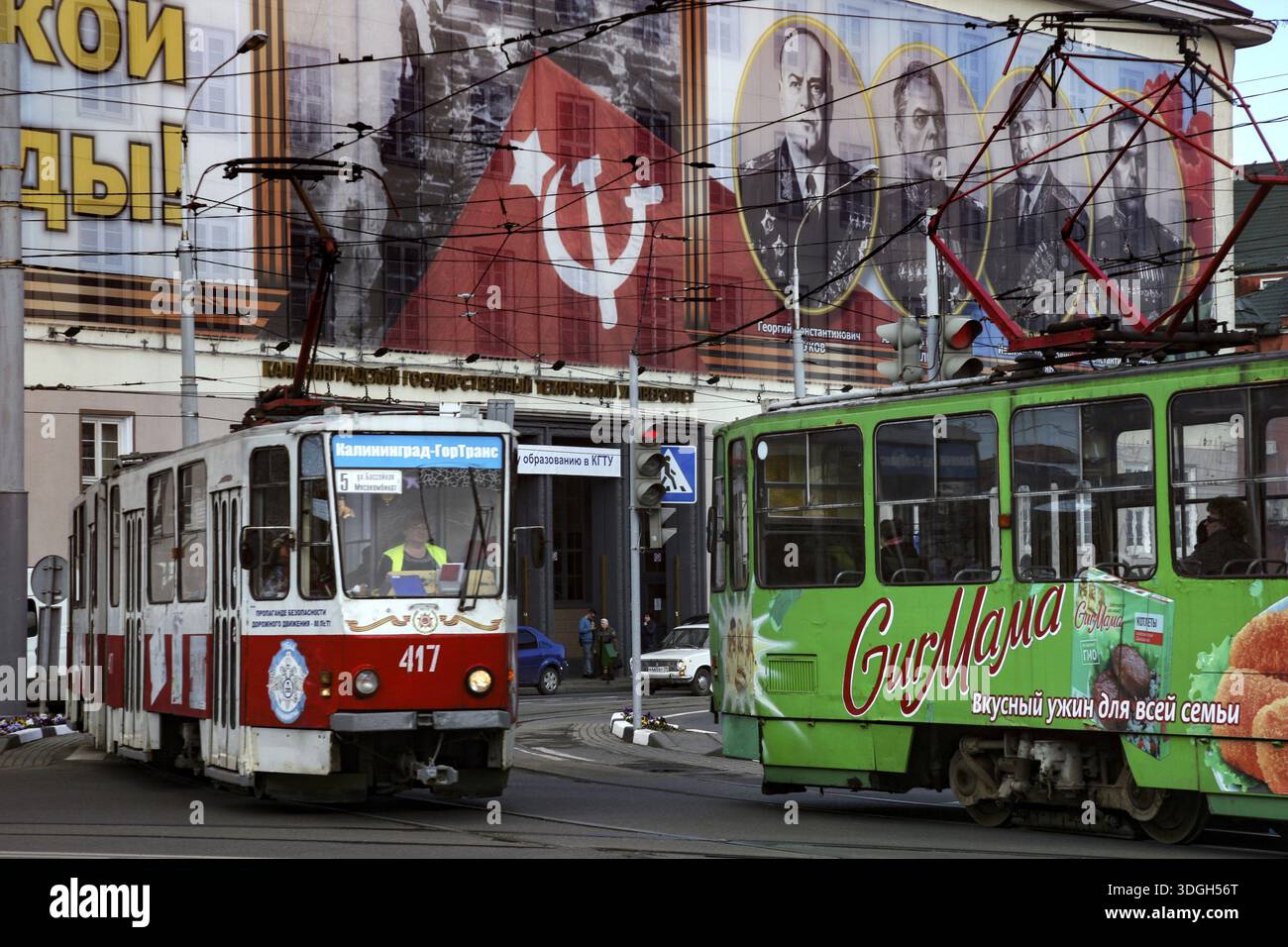 Tramways colorés devant des affiches de propagande soviétique, Kaliningrad, Russie Banque D'Images