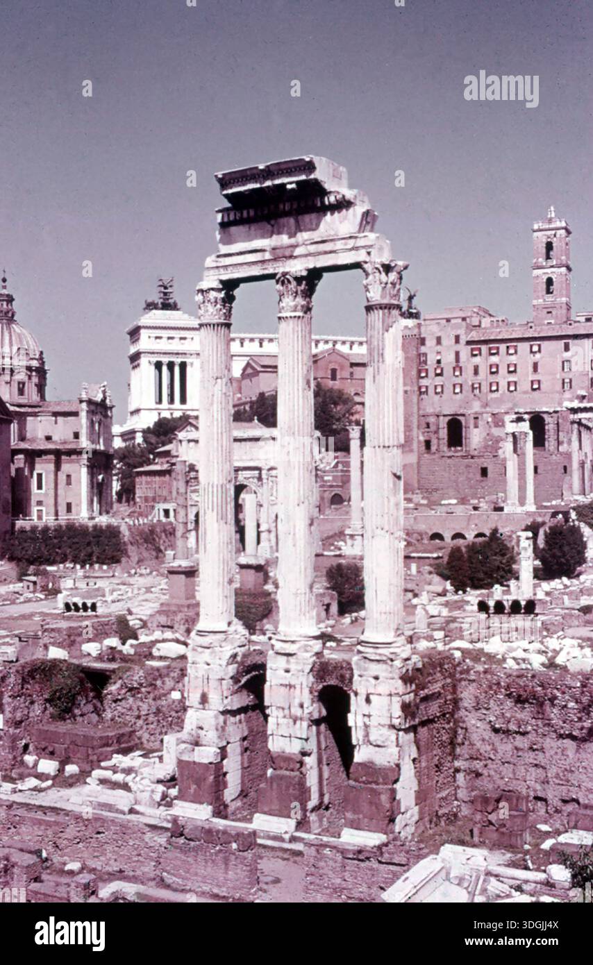 Dans la Rome antique, le forum était le marché et le lieu de rencontre et consistait en une place ouverte entourée de bâtiments publics. Le forum le plus connu est celui de Rome, représenté ici sur une photo de 1970. Les trois colonnes debout au centre faisaient autrefois partie du temple de Castor et Pollux. Derrière, à gauche, vous pouvez voir la Rostra (la plate-forme des locuteurs romains anciens). En arrière-plan à gauche, le « bâtiment blanc » est le monument national Victor-Emmanuel II, construit entre 1885 et 1935. Banque D'Images