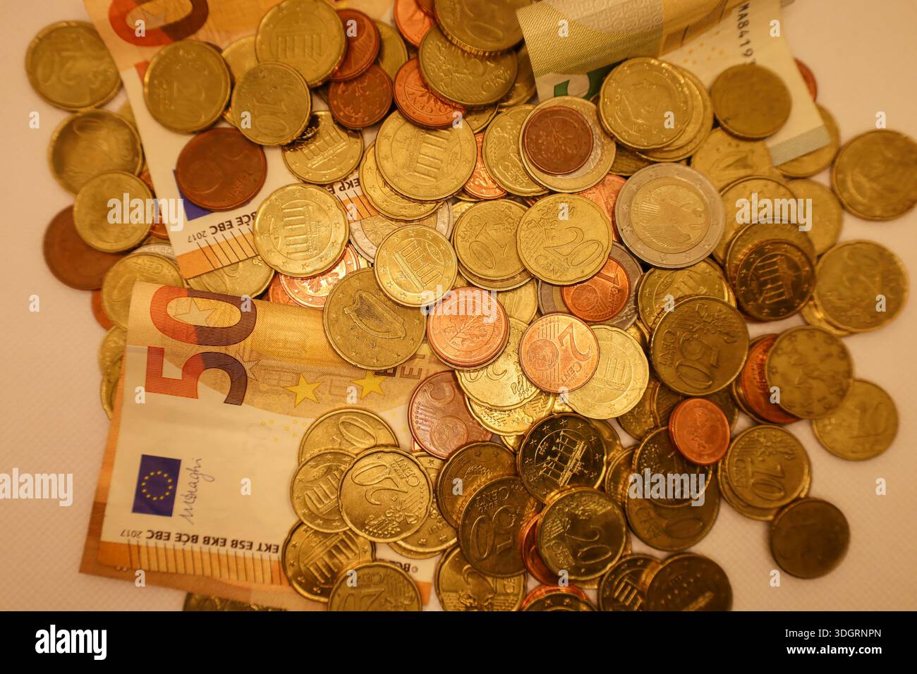 Un affichage vibrant de pièces et de billets de banque se trouve dispersé sur une surface, révélant les divers dessins et dénominations de monnaie de plusieurs Nations Banque D'Images