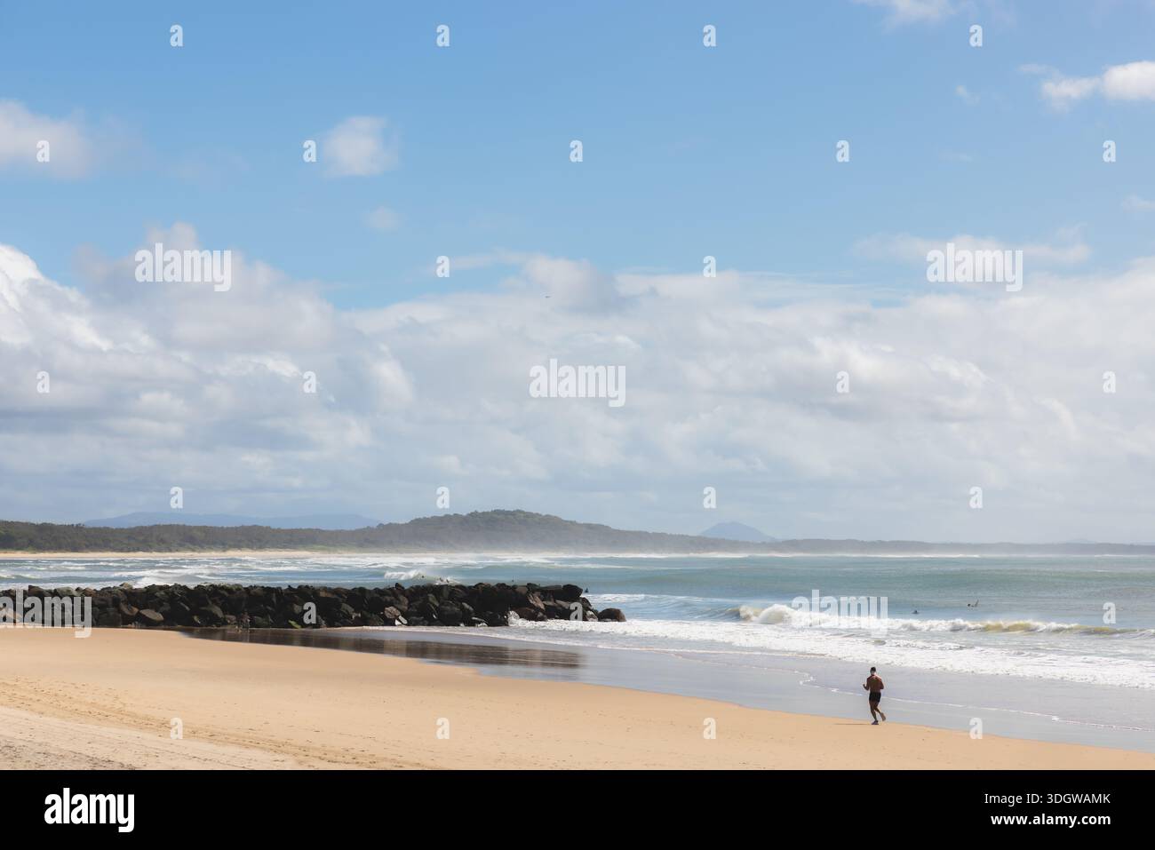 Silhouette d'un homme faisant du jogging sur une longue côte de sable de Noosa Beach à Noosa Heads, Sunshine Coast, Queensland, Australie. Banque D'Images