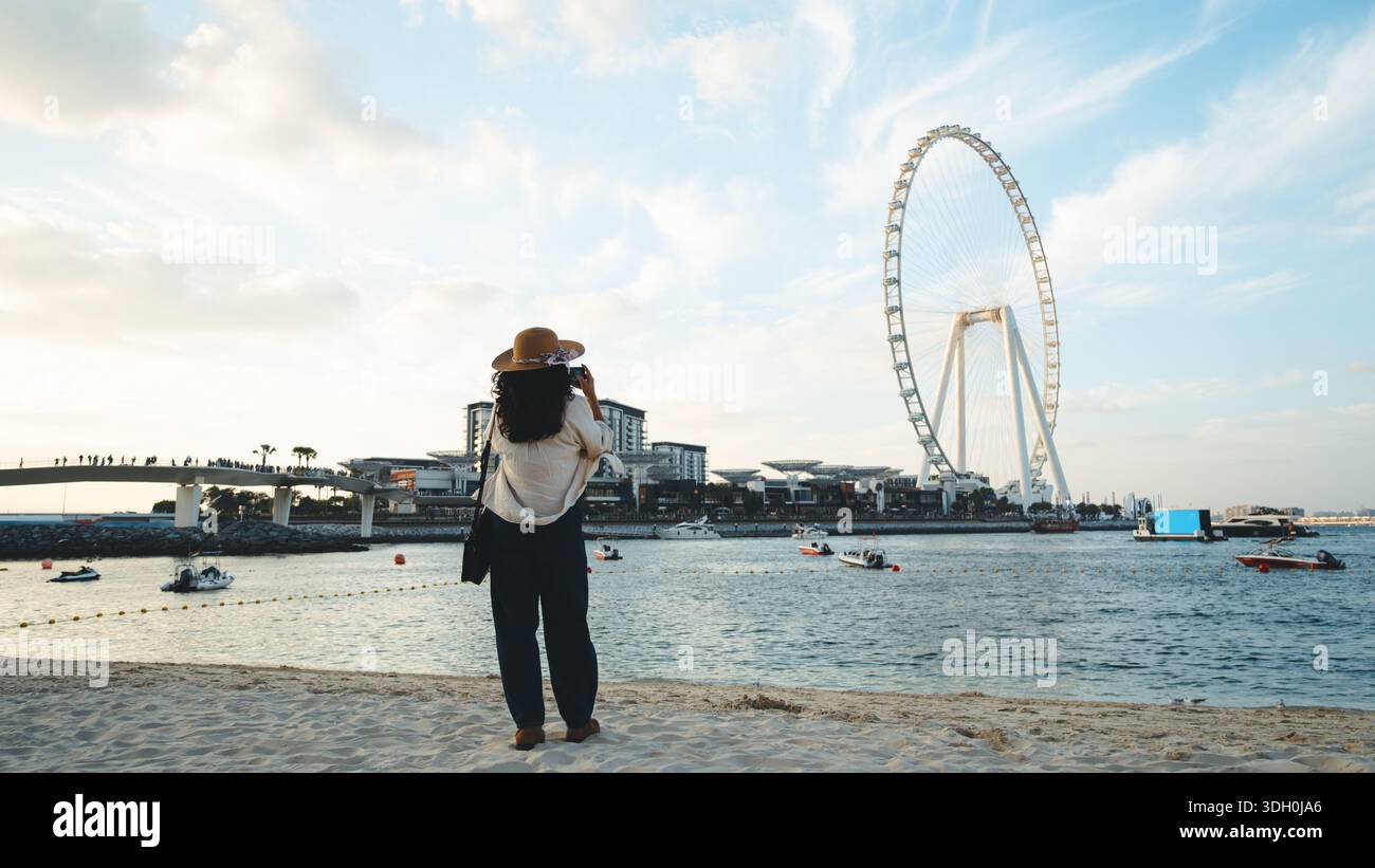 Femme prenant des photos de l'une des plus grandes roues du monde est le Dubai Ain sur l'île bluewaters. Principales attractions touristiques de l'AR unie Banque D'Images