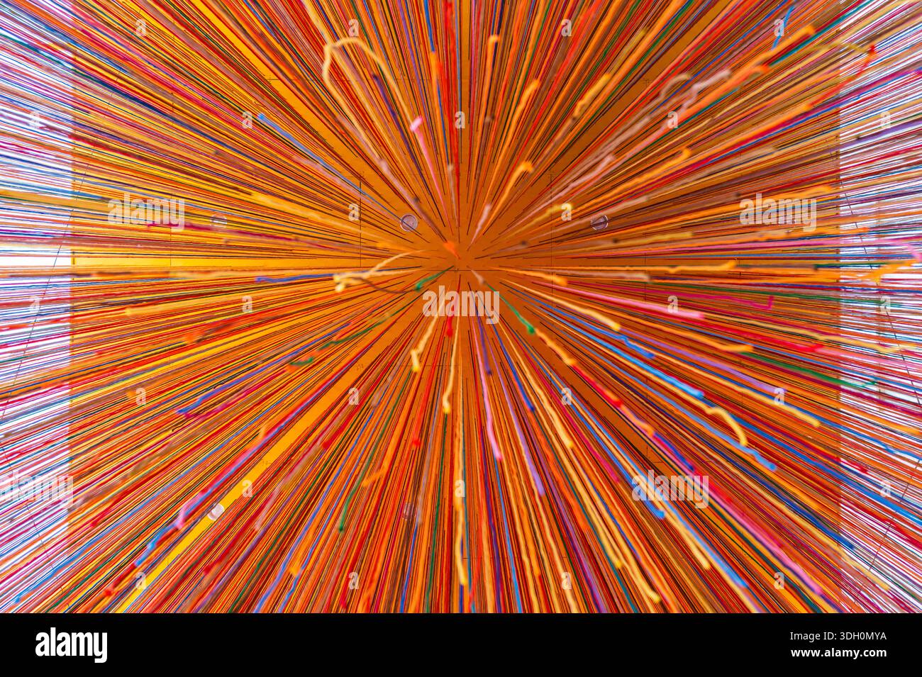 Fond abstrait de fils multicolores suspendus au plafond orange. Banque D'Images