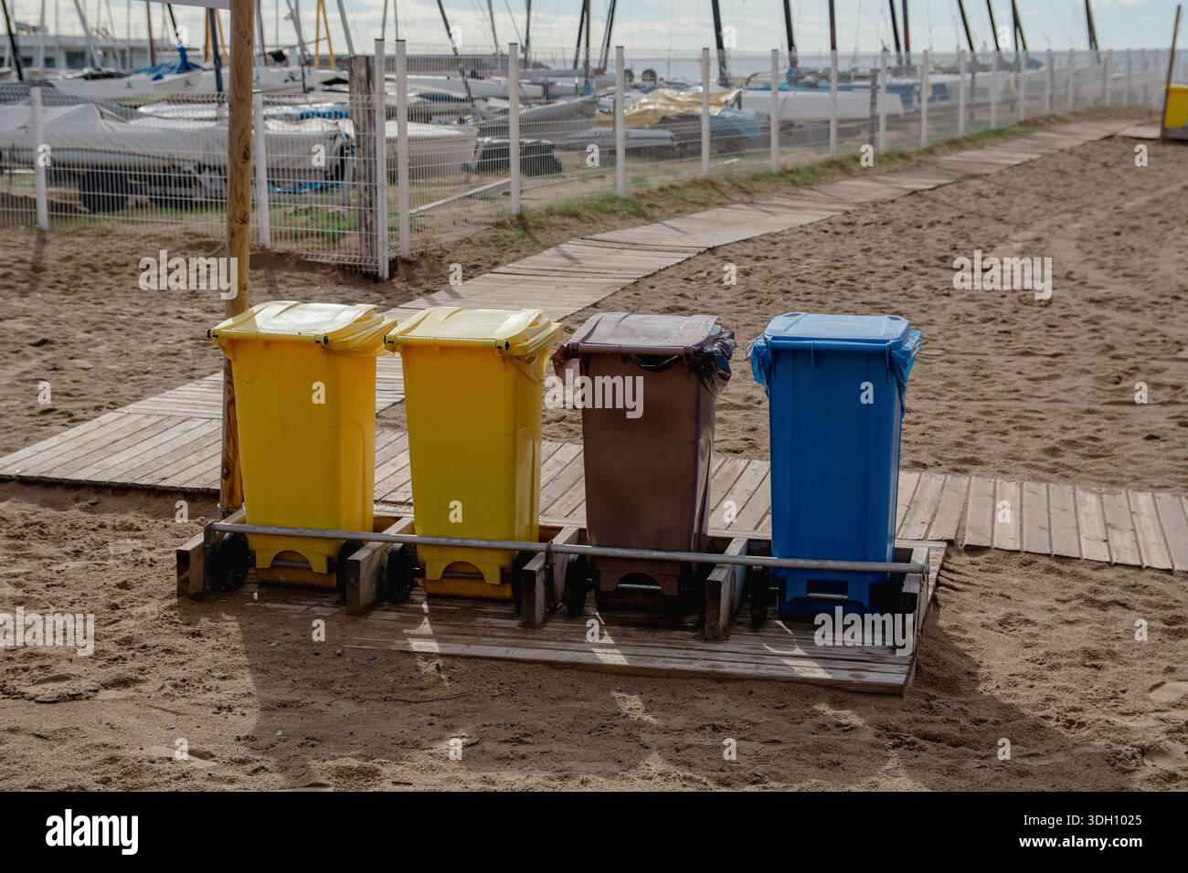 Quatre bacs de recyclage colorés sur la plage pour la collecte séparée des déchets. Concept environnemental favorisant le recyclage, la propreté et le respon écologique Banque D'Images