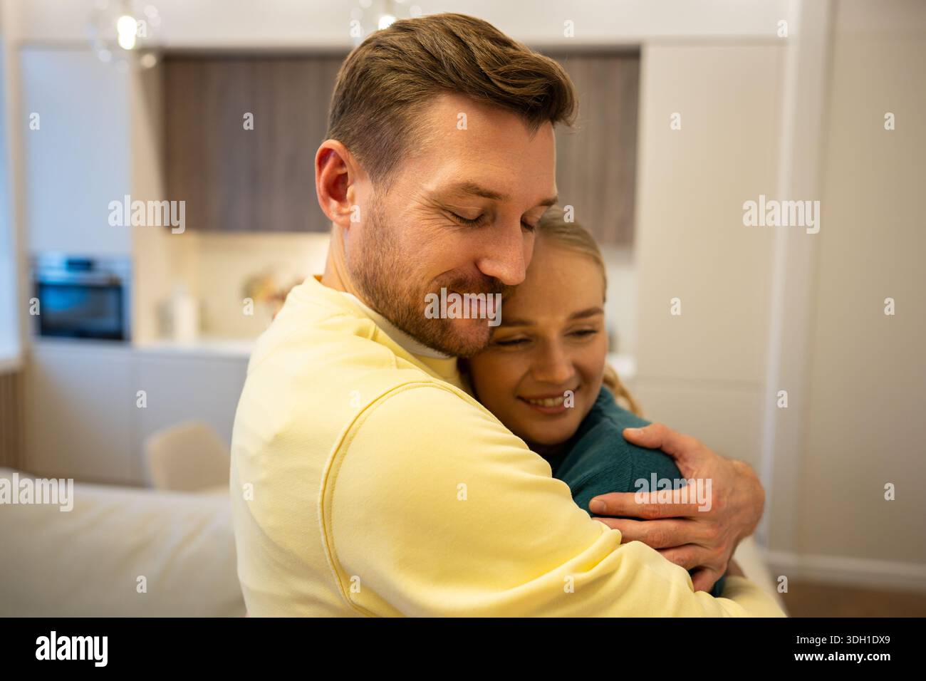 Heureux couple souriant homme et femme embrassant l'un l'autre avec un lien fort et rassurant. Banque D'Images