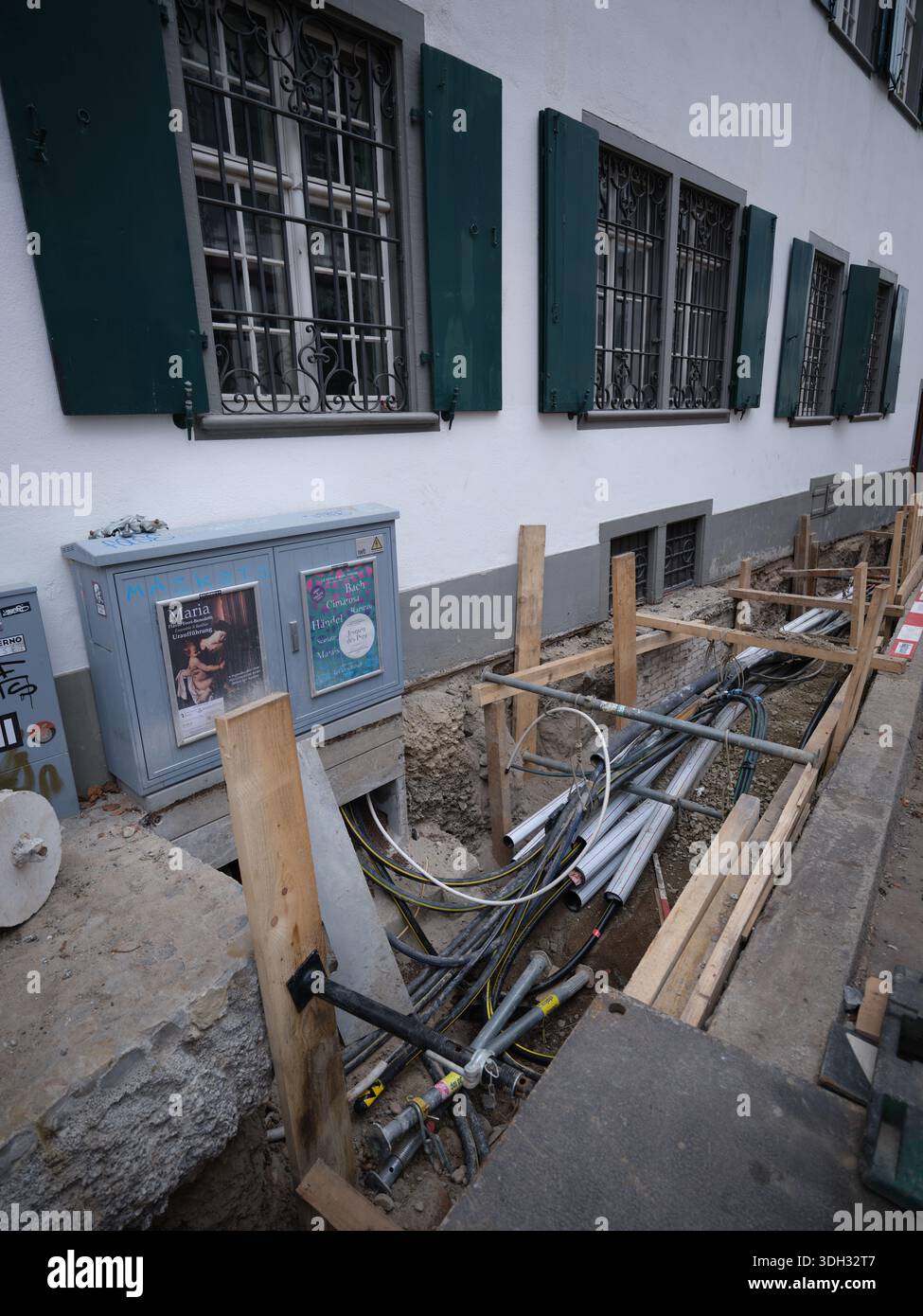 Tuyauteries et infrastructures de services publics exposées dans une tranchée de construction de rue étroite à Bâle Banque D'Images