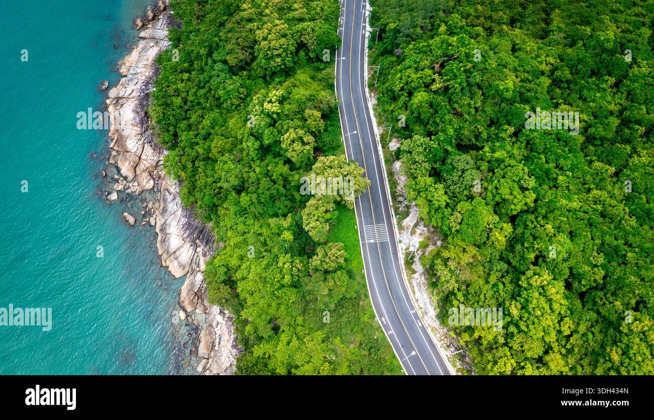 Vue aérienne de la route entre le cocotier et le grand océan en journée à Nakhon si Thammarat, Thaïlande Banque D'Images