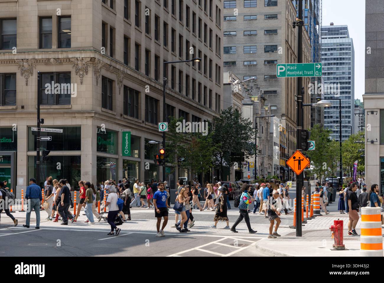 Montréal, Canada - 2 août 2025 : gratte-ciel modernes et passage piétonnier bondé au centre-ville. Les gens traversant la rue dans une ville urbaine animée cen Banque D'Images