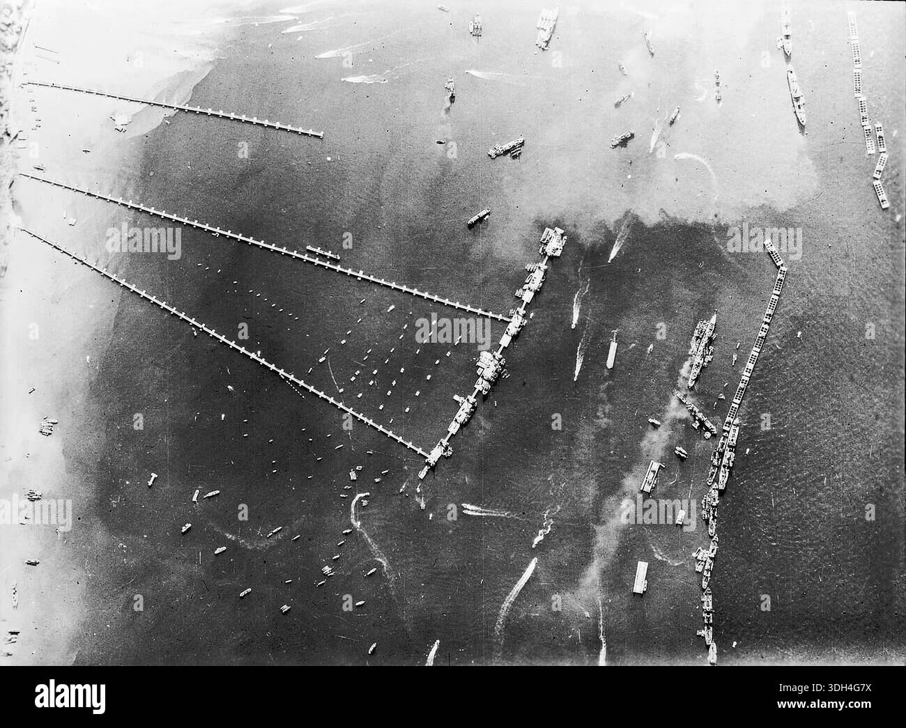 Vue aérienne du Mulberry B à Arromanches le 27 octobre 1944. Le Mulberry était un énorme port flottant long d'un kilomètre et demi qui a été remorqué en position. Cette brillante idée a éliminé le besoin de capturer des villes portuaires fortement défendues comme Cherbourg. Le 6 juin 1944, une énorme force d'invasion Alllied impliquant 7000 navires et 140 000 hommes débarque avec succès sur les côtes françaises et établit cinq têtes de plage. Une campagne de tromperie réussie signifiait qu'une grande partie de la résistance allemande était à Calais et que les pertes étaient relativement peu nombreuses compte tenu de l'ampleur et des dangers de l'opération. Banque D'Images