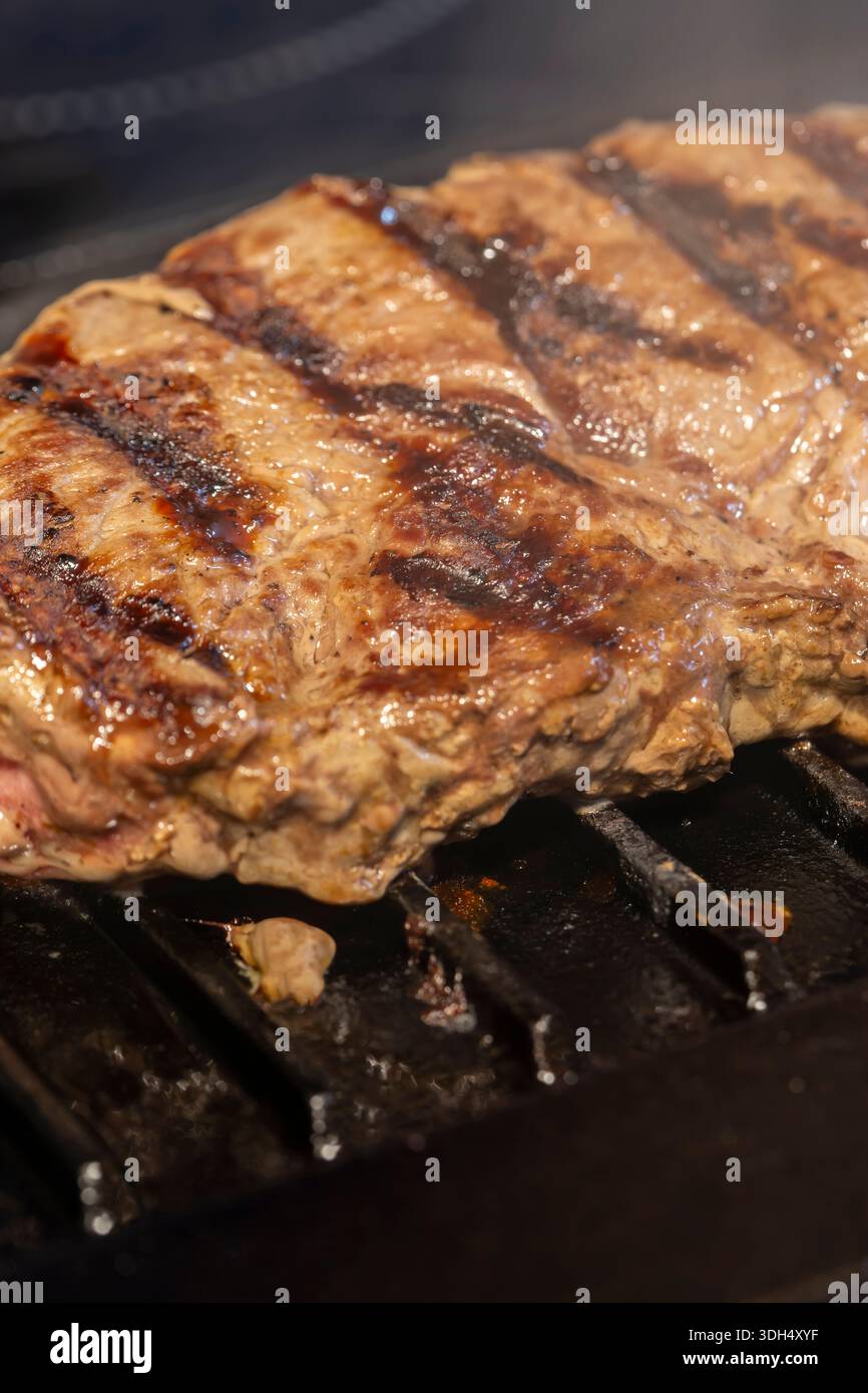 cuisson du steak de croupe de bœuf biologique sur une plaque de cuisson de poêle en fonte fond de plaque de cuisson. Banque D'Images