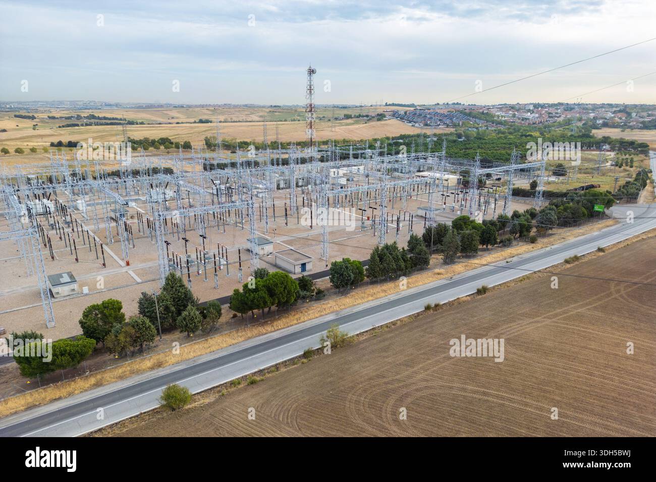 Vue aérienne d'une grande centrale électrique située au milieu des champs ruraux et des zones résidentielles éloignées. L'image montre une sous-station électrique expansive WIT Banque D'Images