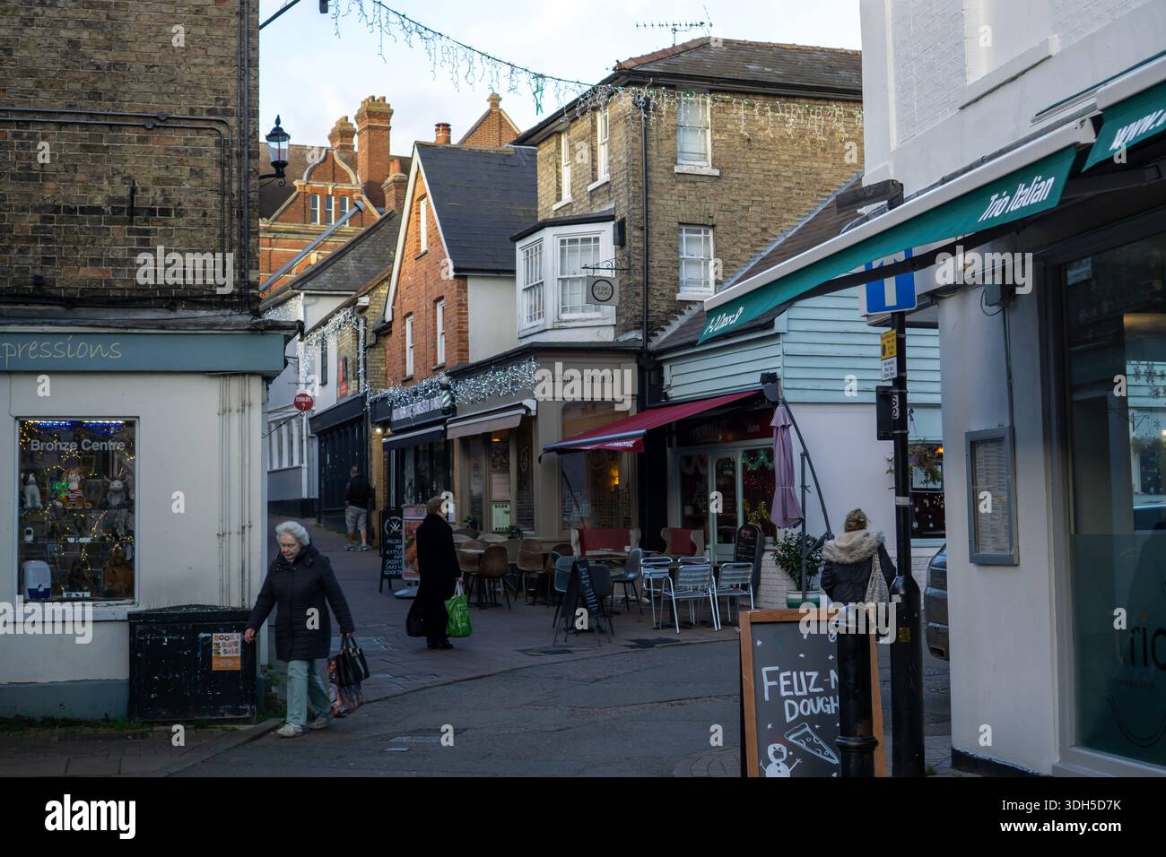 Une rue étroite sinueuse à Saffron Walden avec des boutiques et des cafés décorés pour Noël Banque D'Images