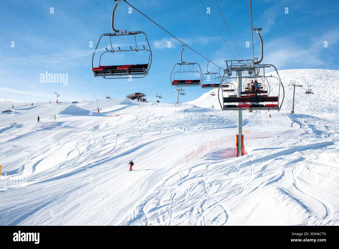 Station de ski ensoleillée transportant des skieurs sur une pente enneigée sous un ciel bleu éclatant dans les Alpes françaises du 20 au 26 janvier, vacances de vacances Banque D'Images