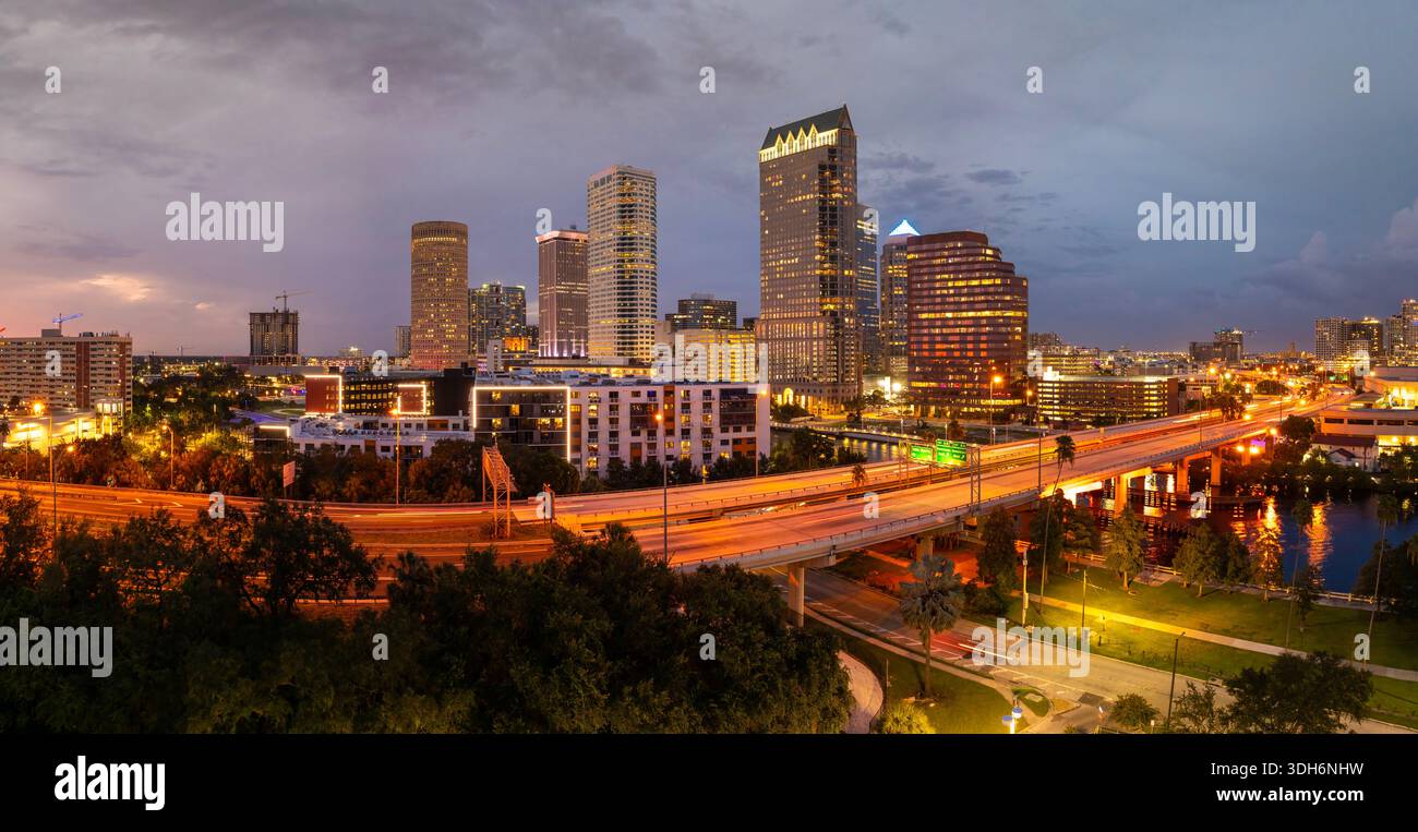 Centre-ville de Tampa ville en Floride, États-Unis. Circulation automobile sur le pont autoroutier au-dessus de la rivière Hillsborough et hauts gratte-ciel illuminés Banque D'Images