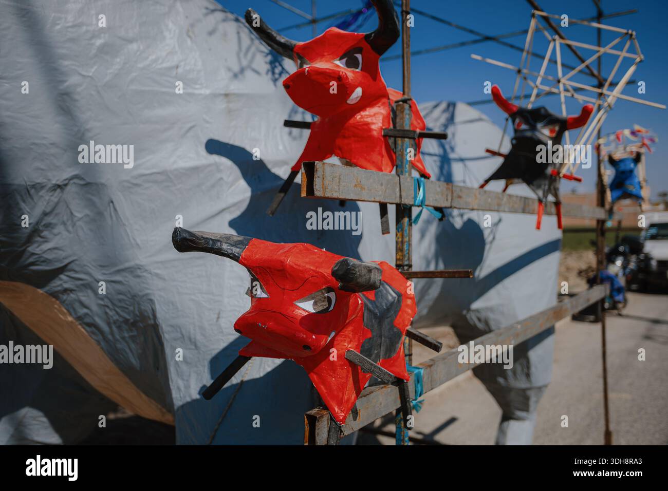 Plusieurs petites mâché têtes de taureau en papier rouge montées sur un cadre métallique lors des préparatifs pour un festival culturel traditionnel au Mexique. Banque D'Images