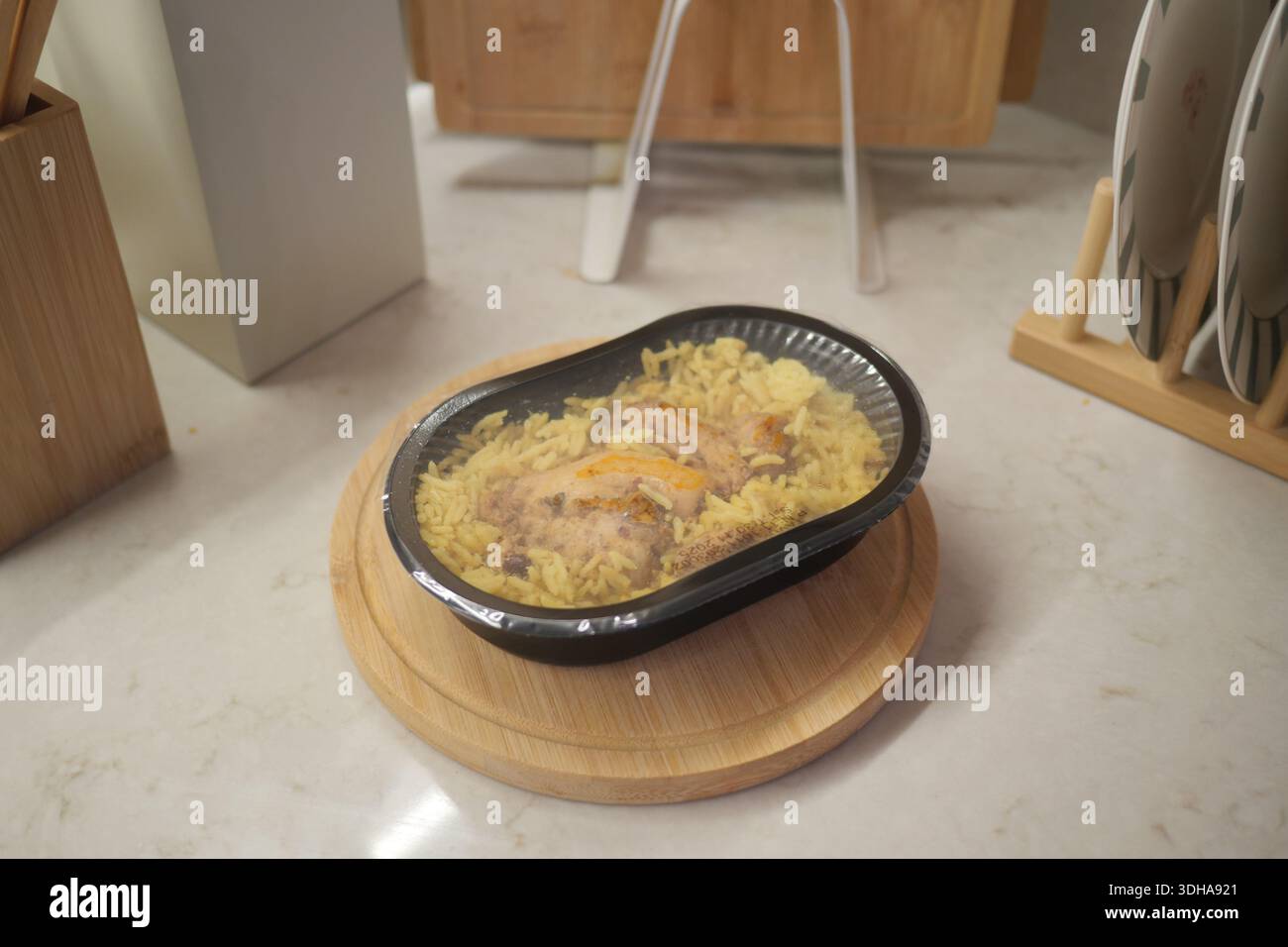 Farine de poulet et de riz dans un récipient noir sur une planche de bois Banque D'Images