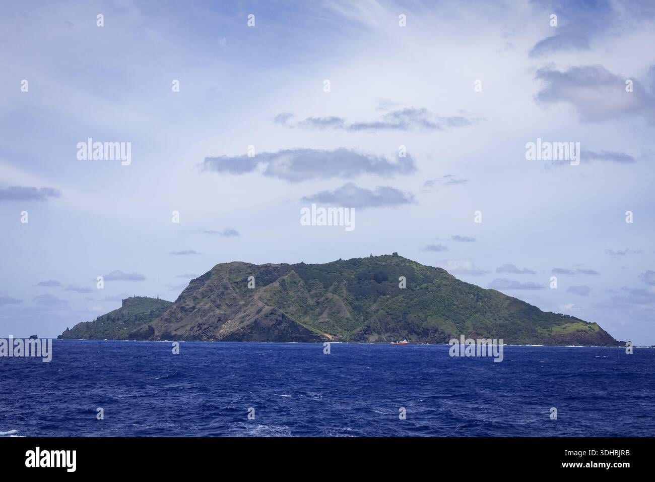 Vue d'une île verdoyante s'élevant de la mer bleue profonde sous un ciel nuageux, Adamstown, territoire britannique d'outre-mer dans l'océan Pacifique, Pitcairn Isl Banque D'Images