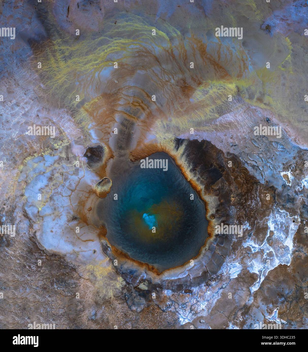 Vue aérienne d'un paysage surréaliste et surréaliste où une piscine turquoise dynamique reflète le ciel au milieu de motifs tourbillonnants d'ocre et de bleus glacés, HVO Banque D'Images