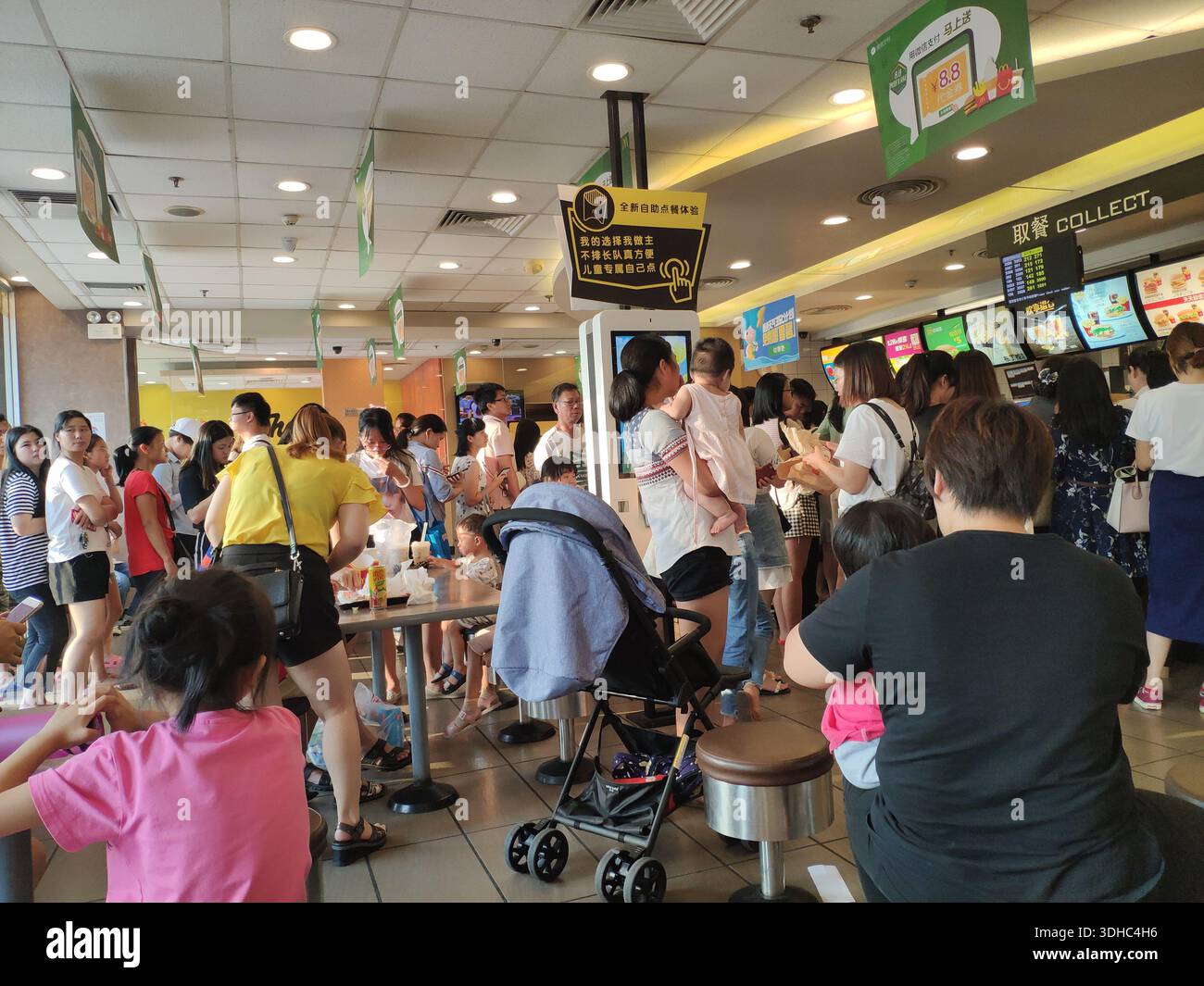 Restaurant McDonald's très fréquenté avec familles et clients en file d'attente Banque D'Images