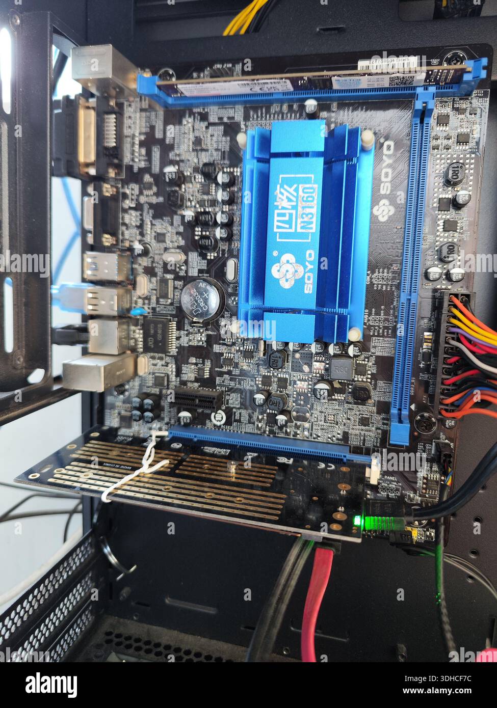 Gros plan d'une carte mère d'ordinateur avec un refroidisseur de processeur bleu installé à l'intérieur du boîtier de l'ordinateur Banque D'Images