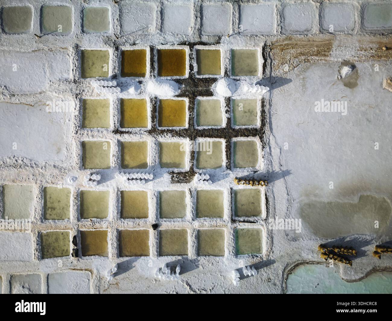 Vue aérienne des étangs de sel géométriques, leurs teintes pastel contrastant avec les cristaux de sel blanc et dur, créant un paysage surréaliste, Daghmar, Oman Banque D'Images