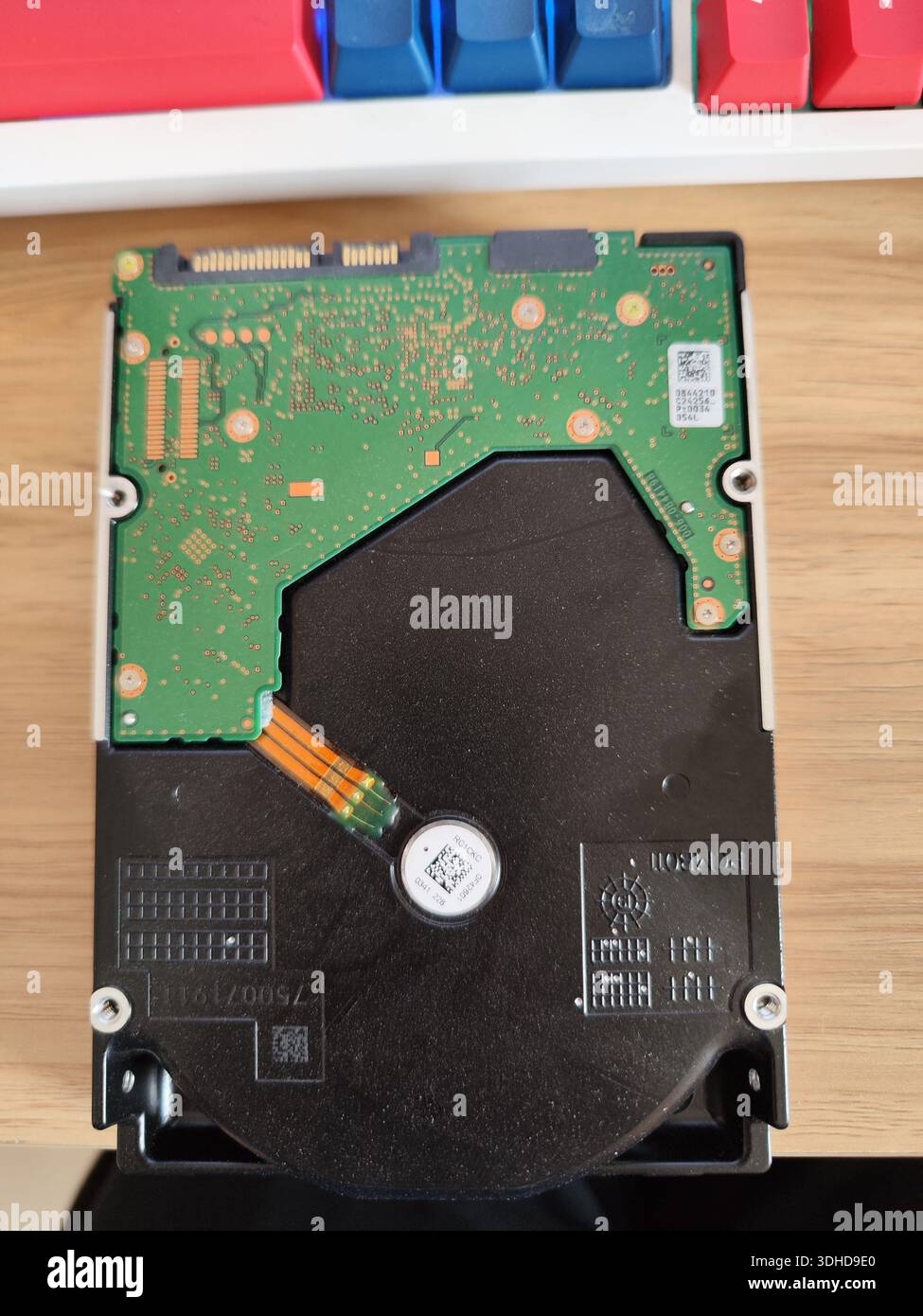 Composant de disque dur interne sur une surface en bois avec clavier en arrière-plan Banque D'Images