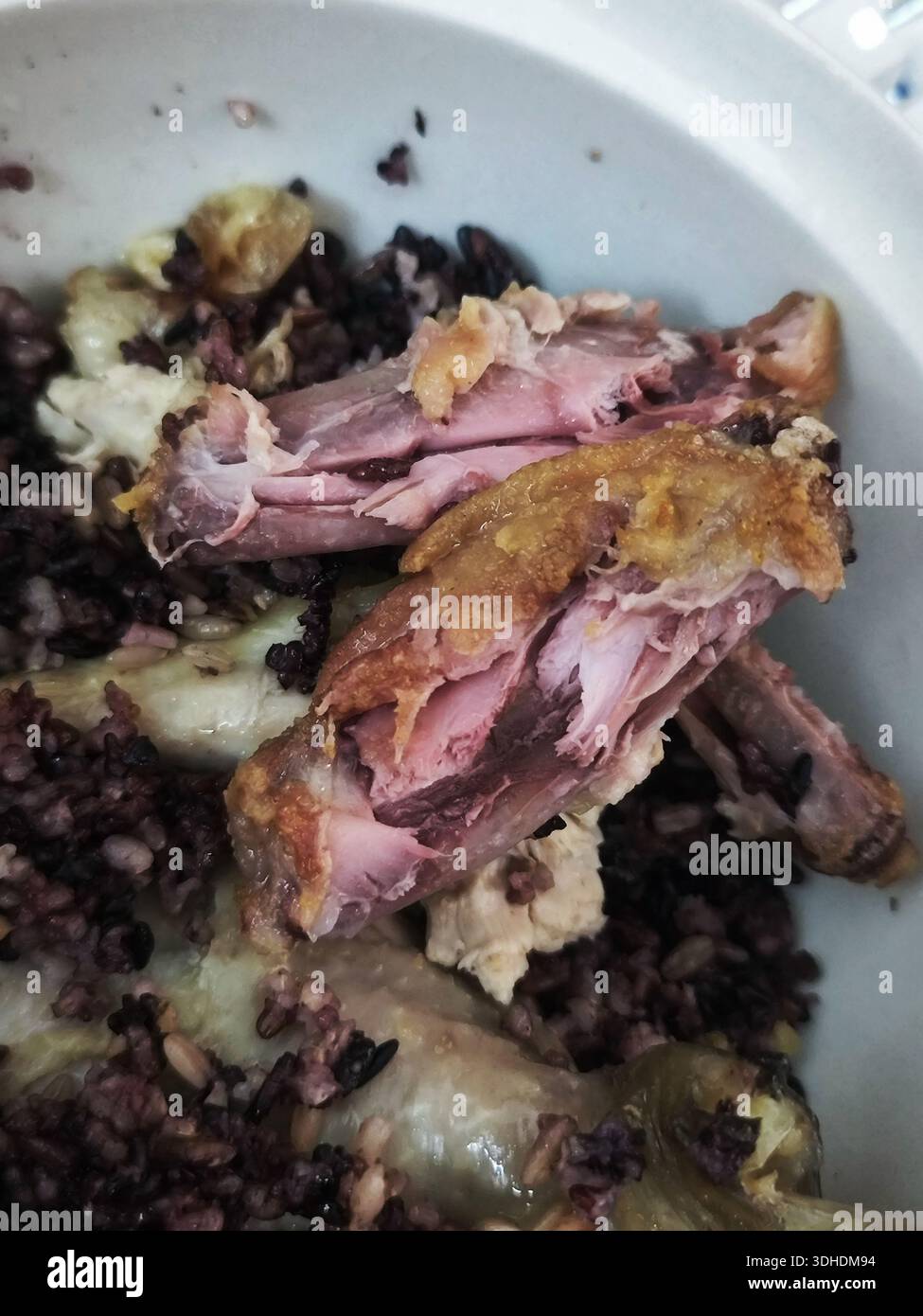 Gros plan de poulet rôti avec du riz noir dans un bol Banque D'Images