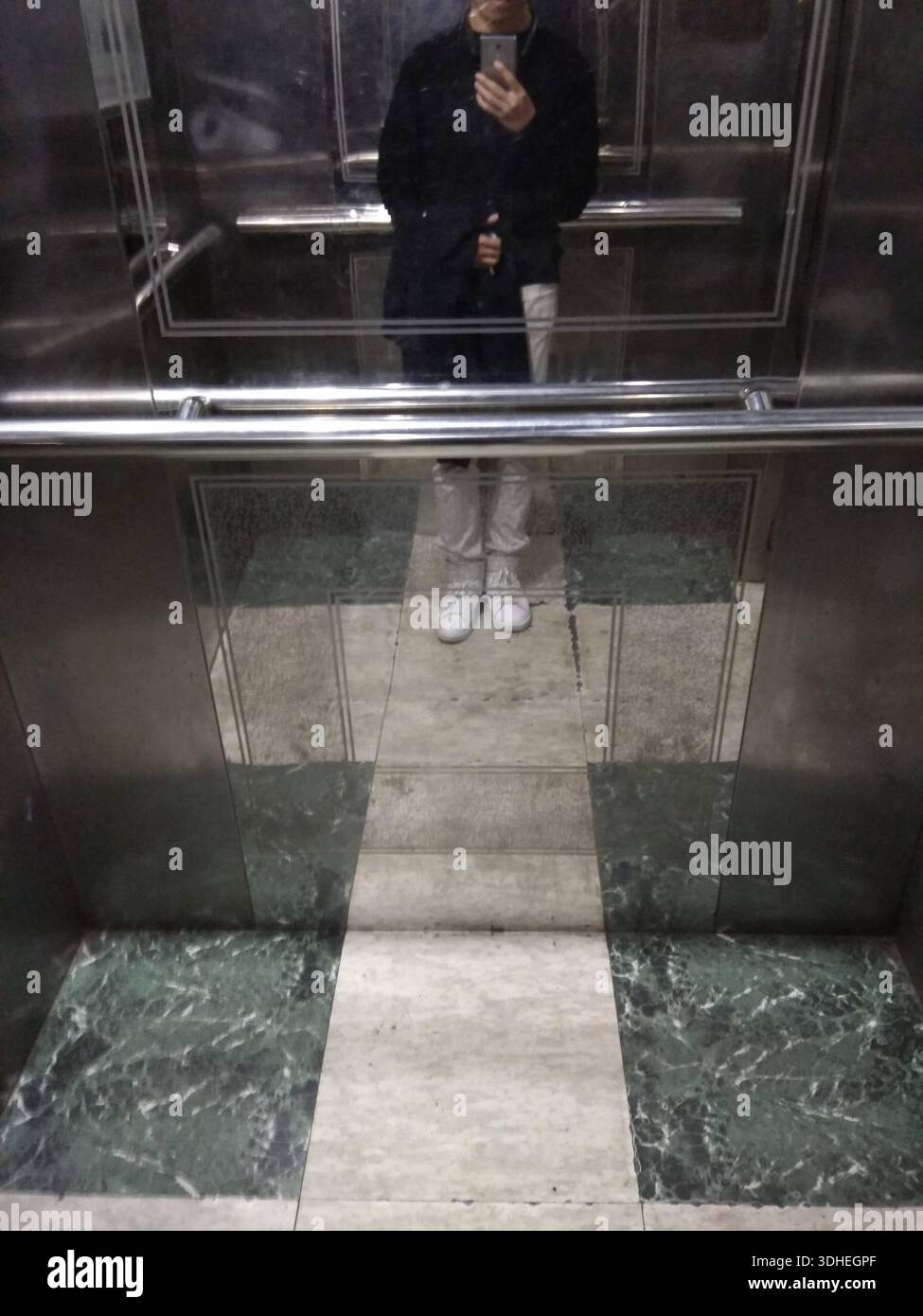 Reflet d'une personne prenant un Selfie dans un miroir d'ascenseur Banque D'Images