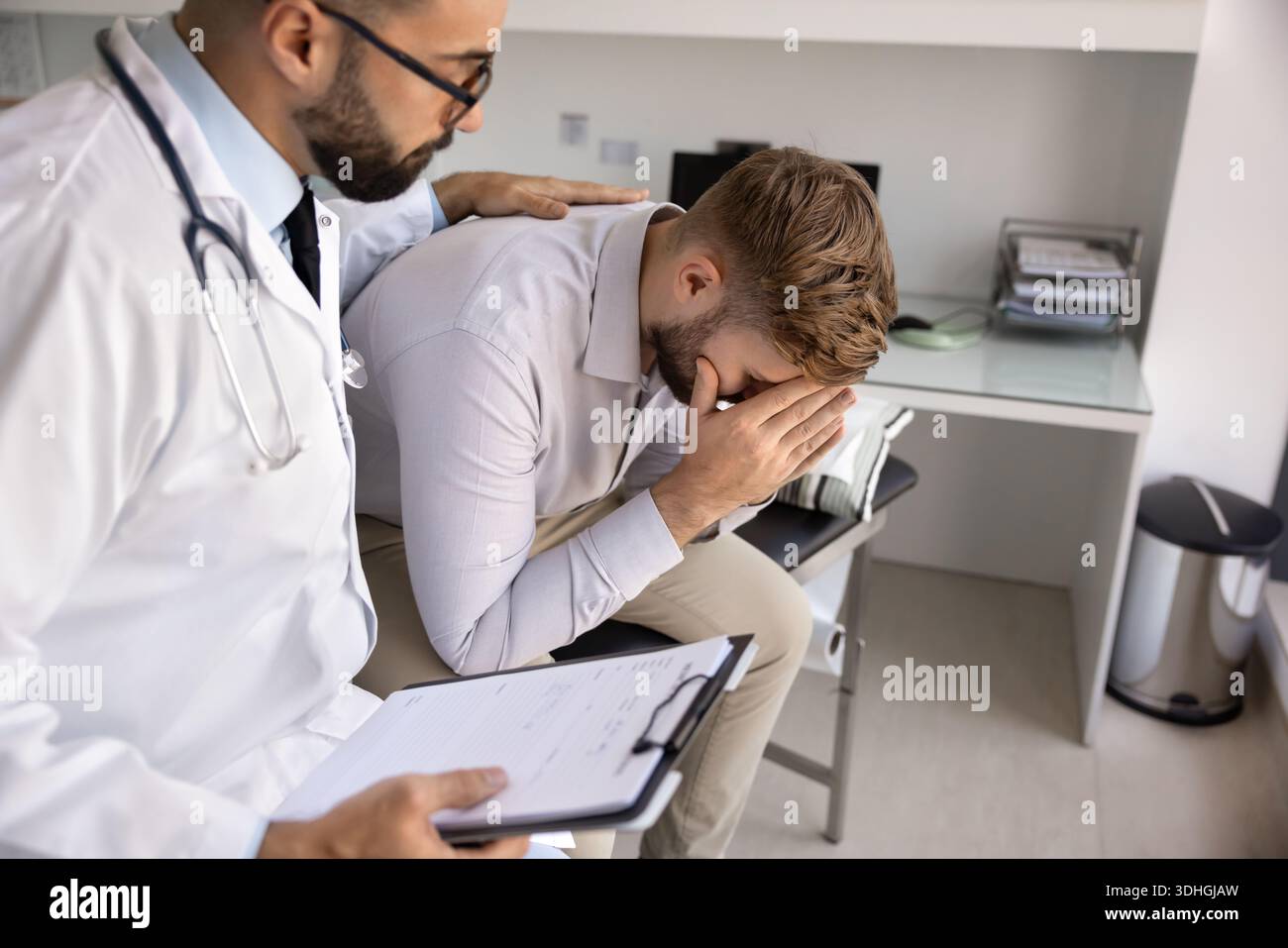 Jeune médecin empathique apaisant le patient de confort cachant la face dans les paumes Banque D'Images