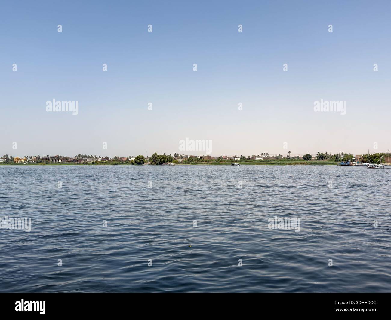 Ägypten Nil : Dorf mit Turm, Palmen und blauem Boot am Ufer - Image de stock capturée avec un smartphone