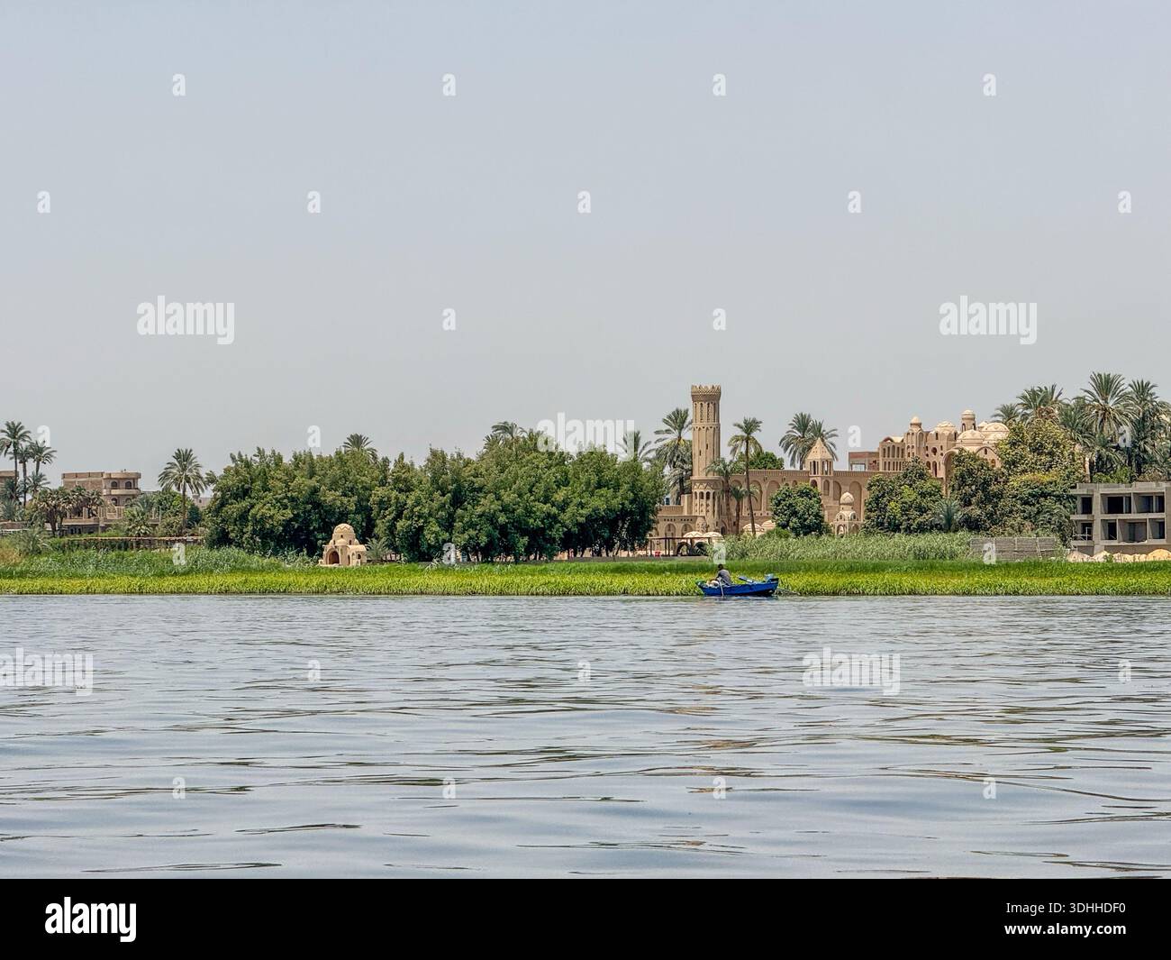 Ägypten Nil : Dorf mit Turm, Palmen und blauem Boot am Ufer - Image de stock capturée avec un smartphone