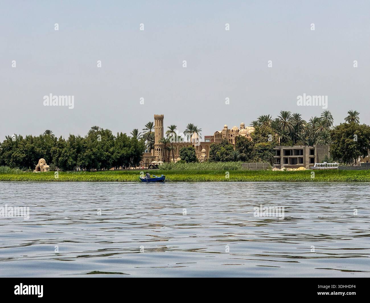 Ägypten Nil : Dorf mit Turm, Palmen und blauem Boot am Ufer - Image de stock capturée avec un smartphone
