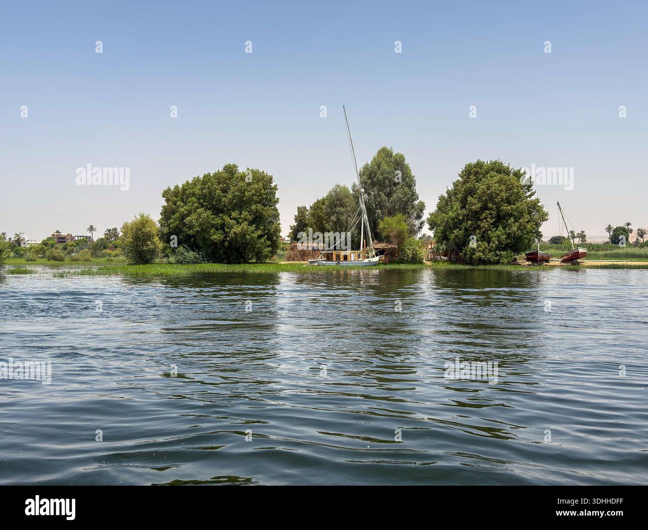 Ägypten Nil : Dorf mit Turm, Palmen und blauem Boot am Ufer - Image de stock capturée avec un smartphone