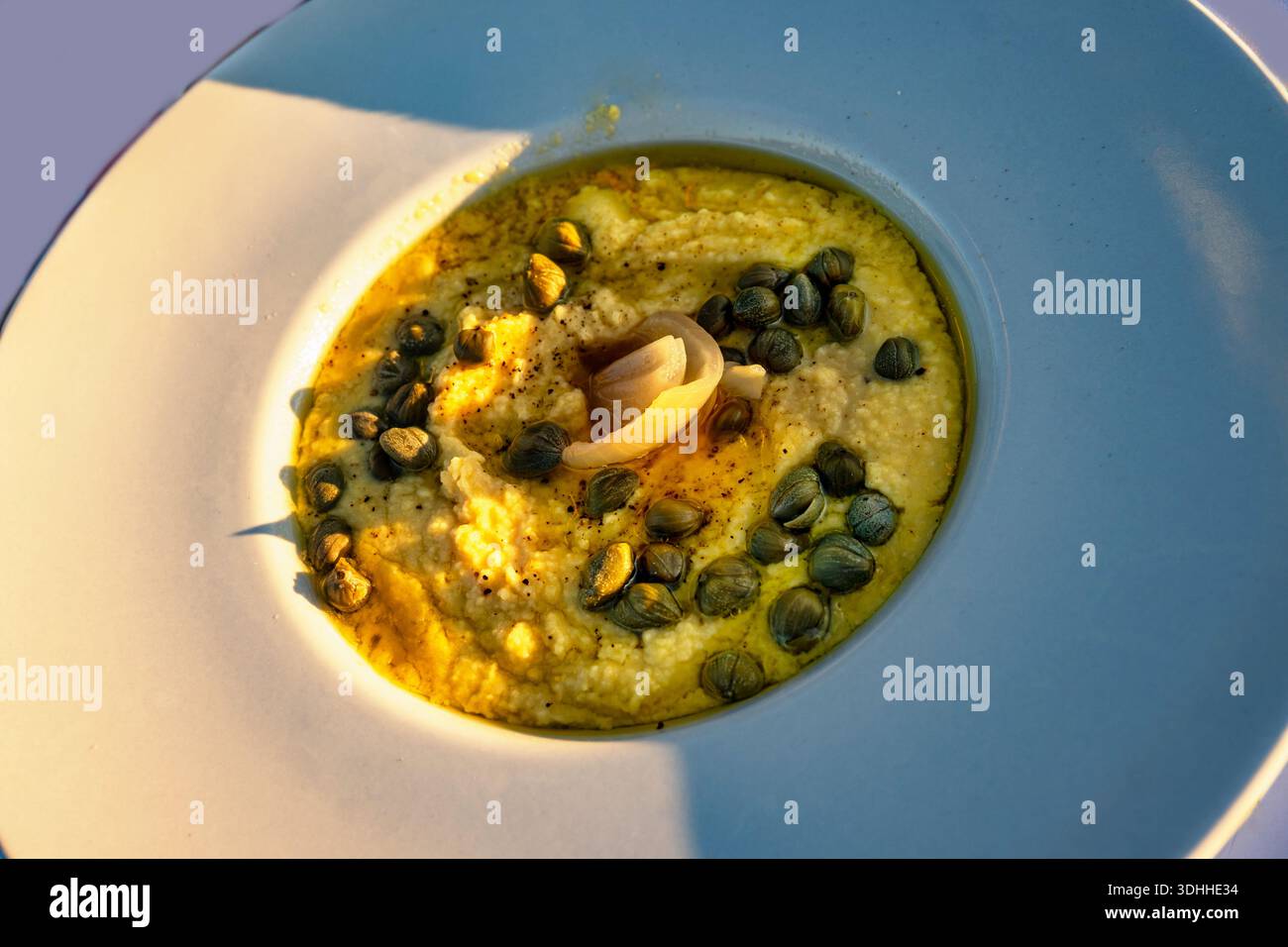 Purée de fava grecque traditionnelle avec capsuleuse et oignon dans l'assiette, gros plan. Banque D'Images