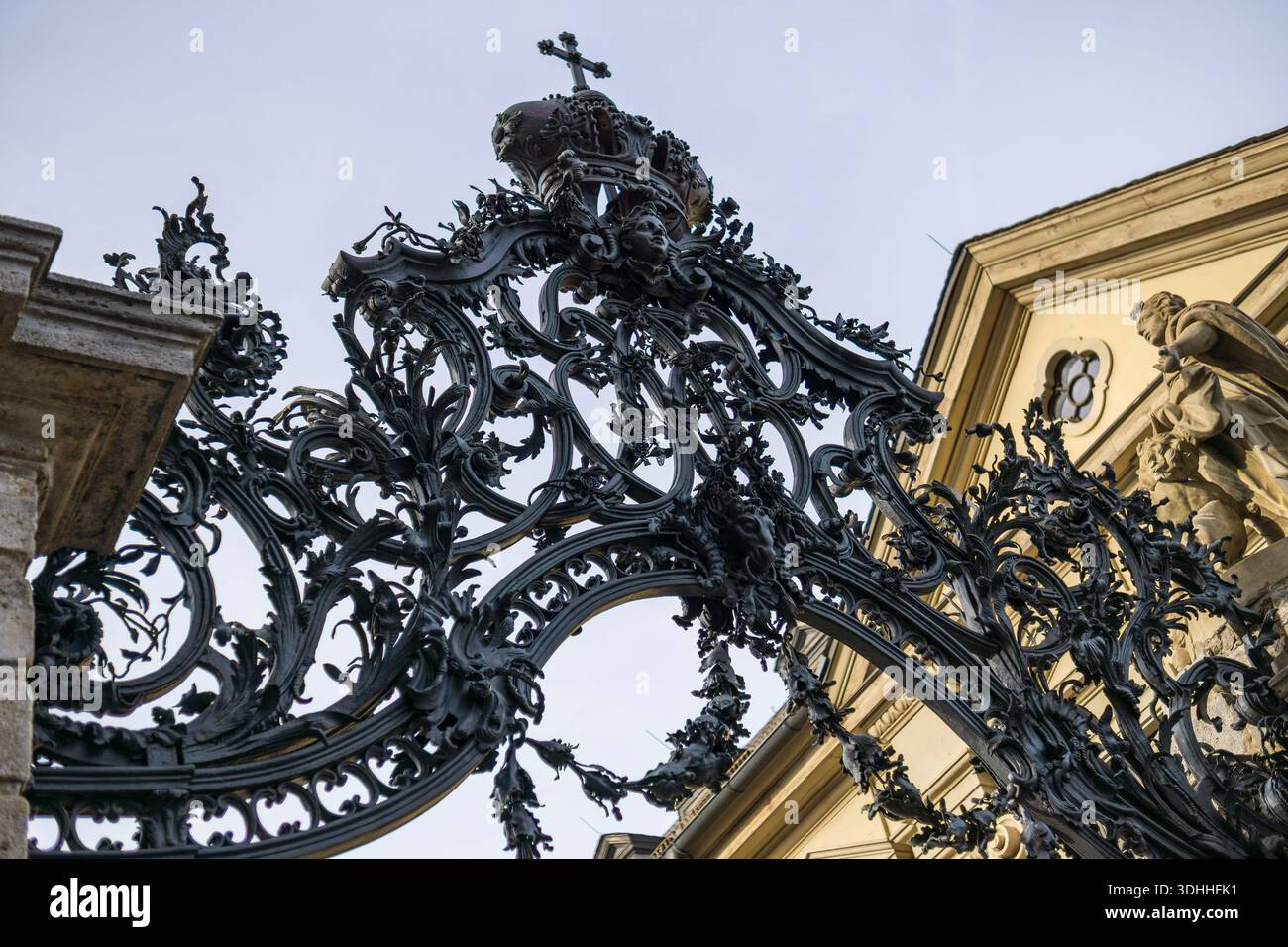 Vue détaillée d'une porte baroque en fer forgé ornée d'une couronne royale et d'une croix religieuse à la résidence de Wurzburg en Allemagne. Banque D'Images