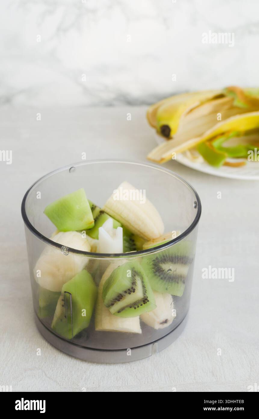 Ingrédients pour smoothie : morceaux de banane et kiwi dans un bol de mixeur. Fruits brillants pour un repas sain. Concept de bol de petit déjeuner ou repas coloré. V Banque D'Images