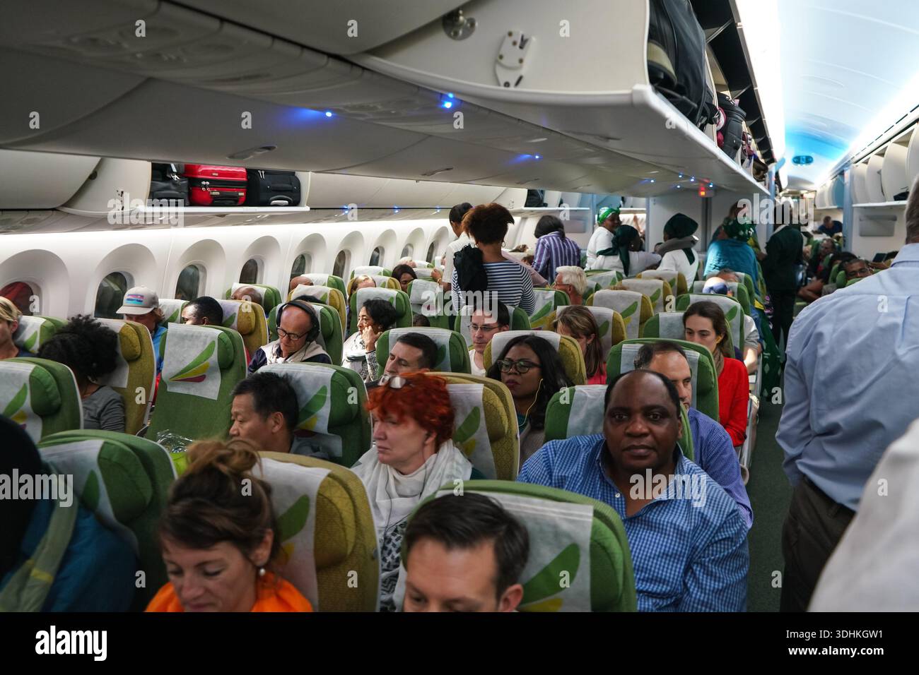 Schwechat, Autriche - 22 avril 2019 : les passagers se sont assis à leur place dans un avion commercial peu de temps avant le départ, les casiers suspendus encore Banque D'Images