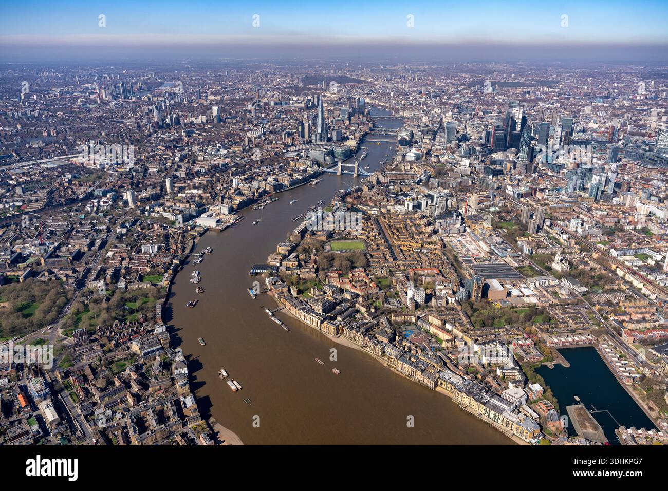 Vue aérienne de la Tamise serpentine serpentant son chemin à travers le cœur de la ville, devant des monuments emblématiques comme Tower Bridge et gratte-ciel moderne Banque D'Images