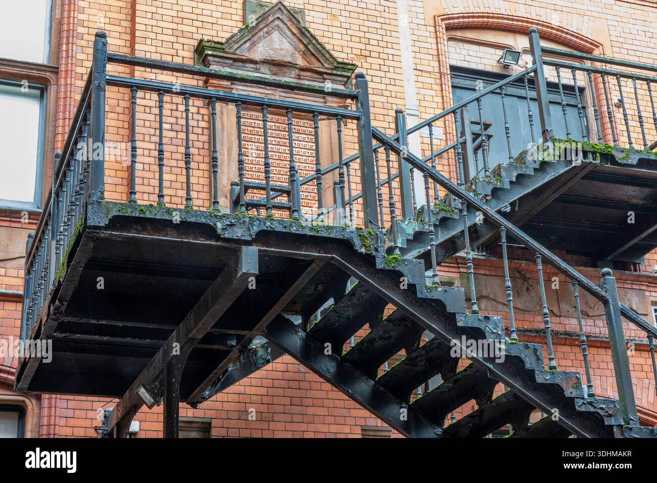 Vieil escalier d'évacuation en fonte à l'extérieur d'un bâtiment industriel historique en briques rouges dans le centre-ville de Cardiff, pays de Galles du Sud, Royaume-Uni Banque D'Images