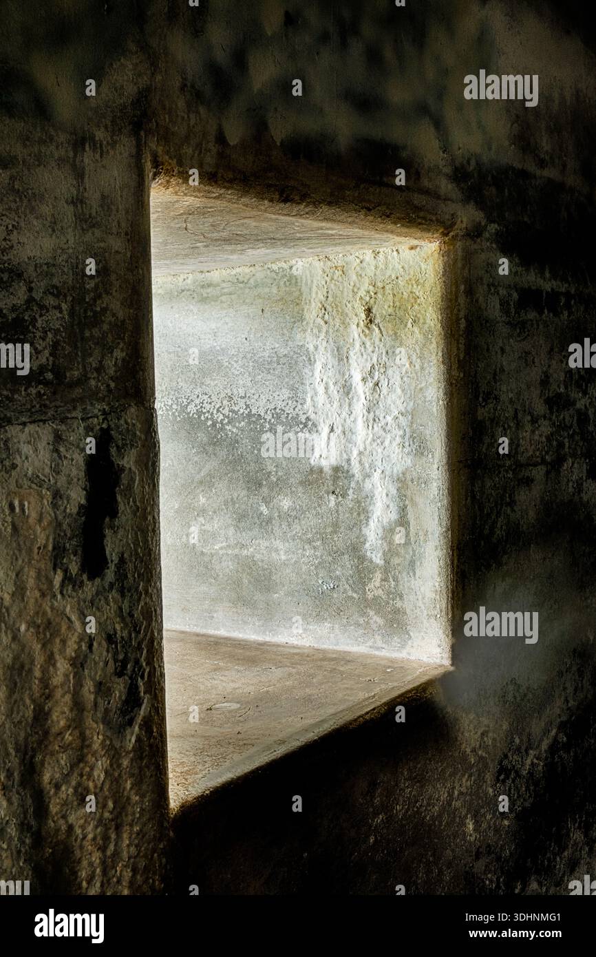 Une ouverture murale laisse entrer la lumière à certaines des pièces souterraines à travers les épais murs de béton de Fort Casey. Banque D'Images