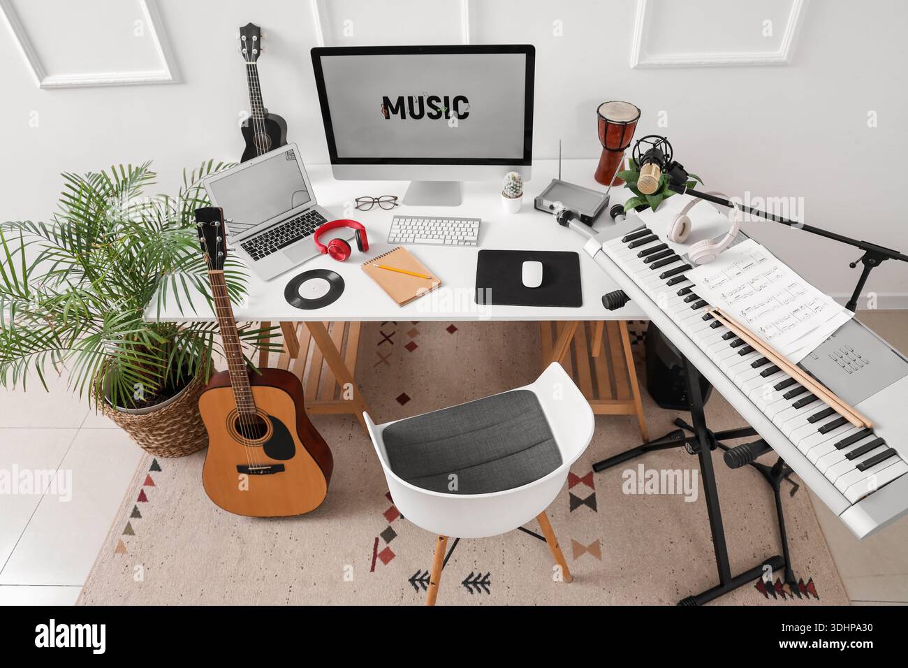 Lieu de travail avec ordinateur et instruments de musique près du mur de lumière dans le studio Banque D'Images