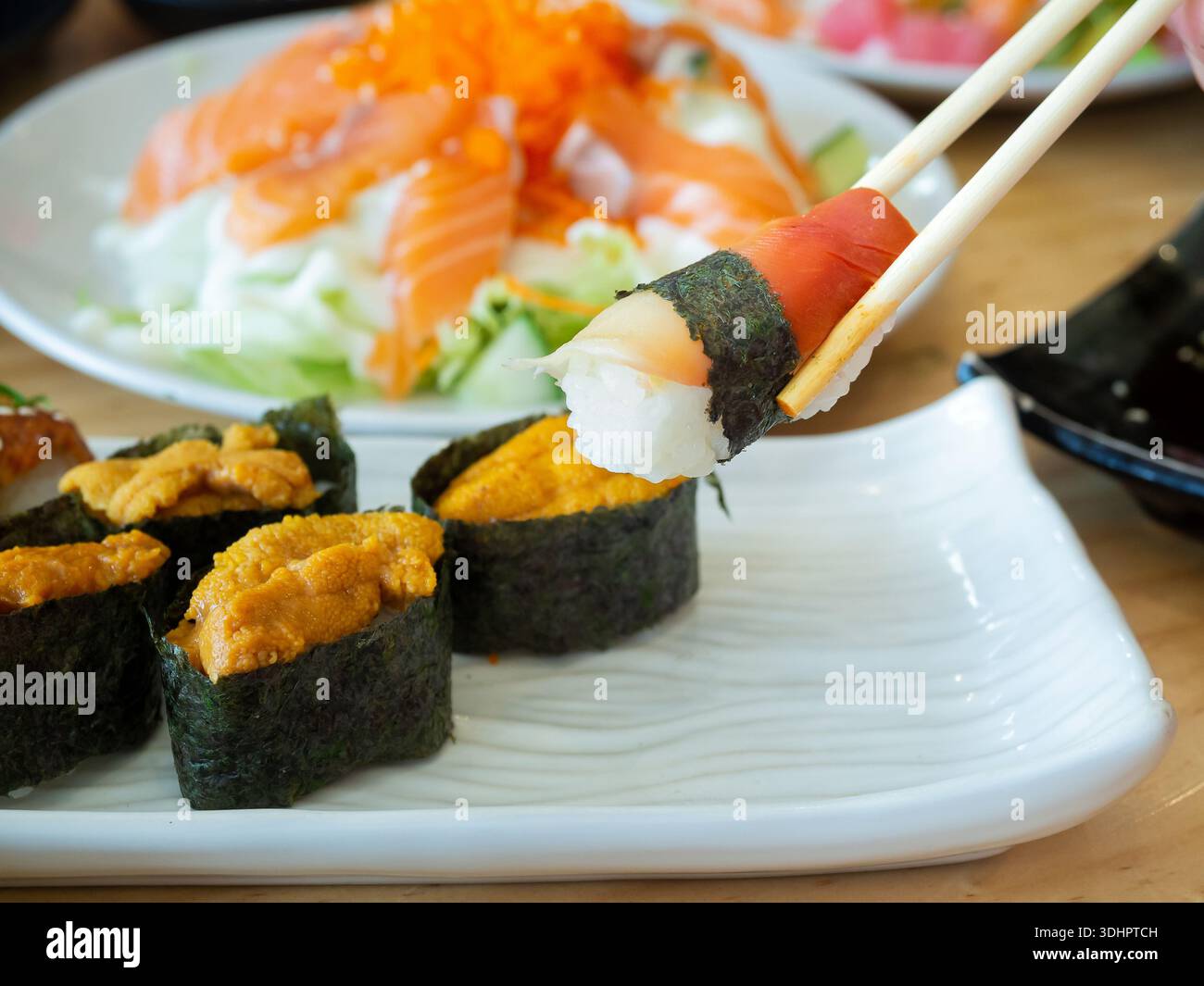 Sushi Hokkigai ou sushi de palourdes de surf Stimpson sur baguettes et sushi d'oursin, cuisine japonaise. Banque D'Images