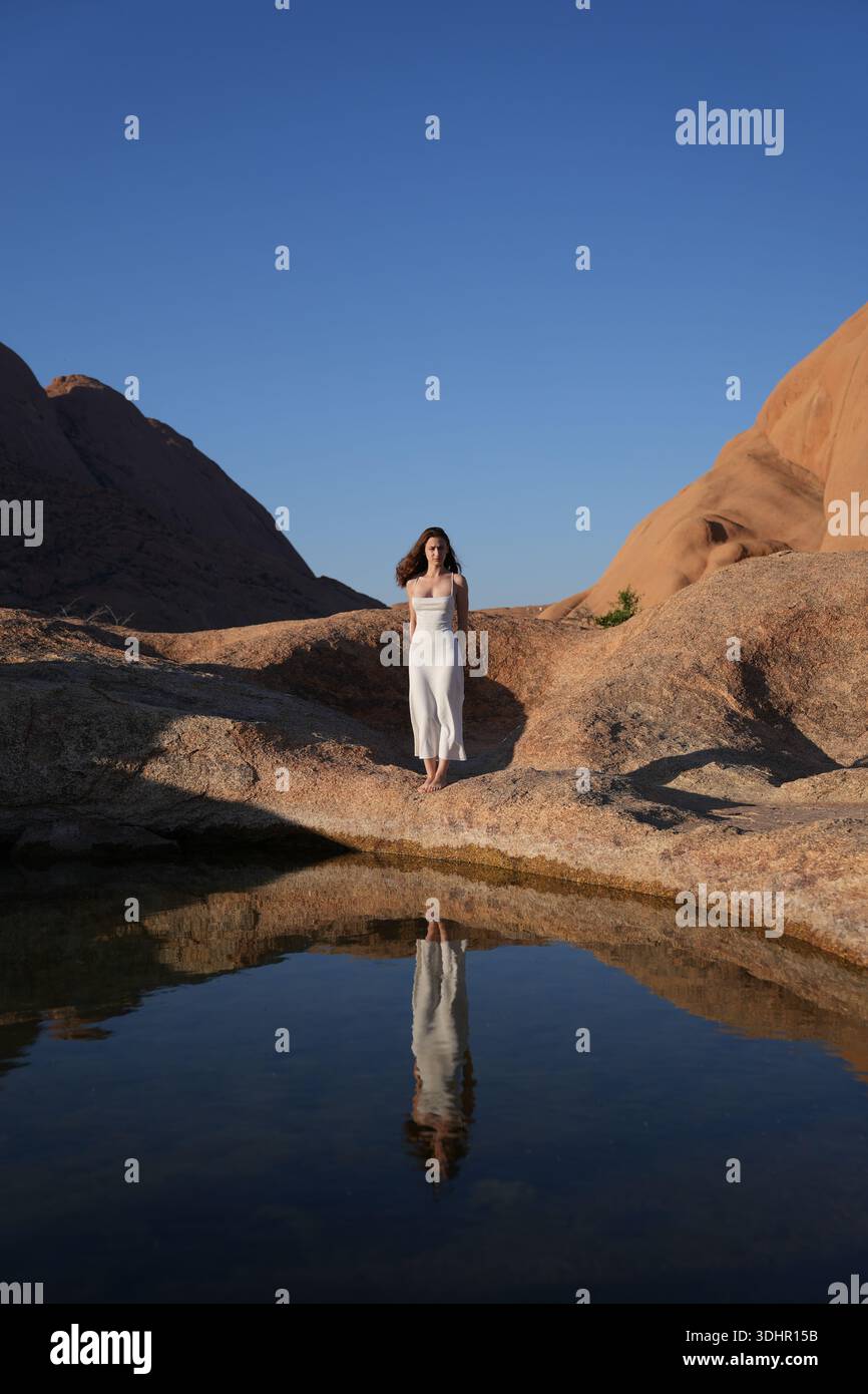 Jeunes femmes en robe blanche au lac de réflexion Banque D'Images