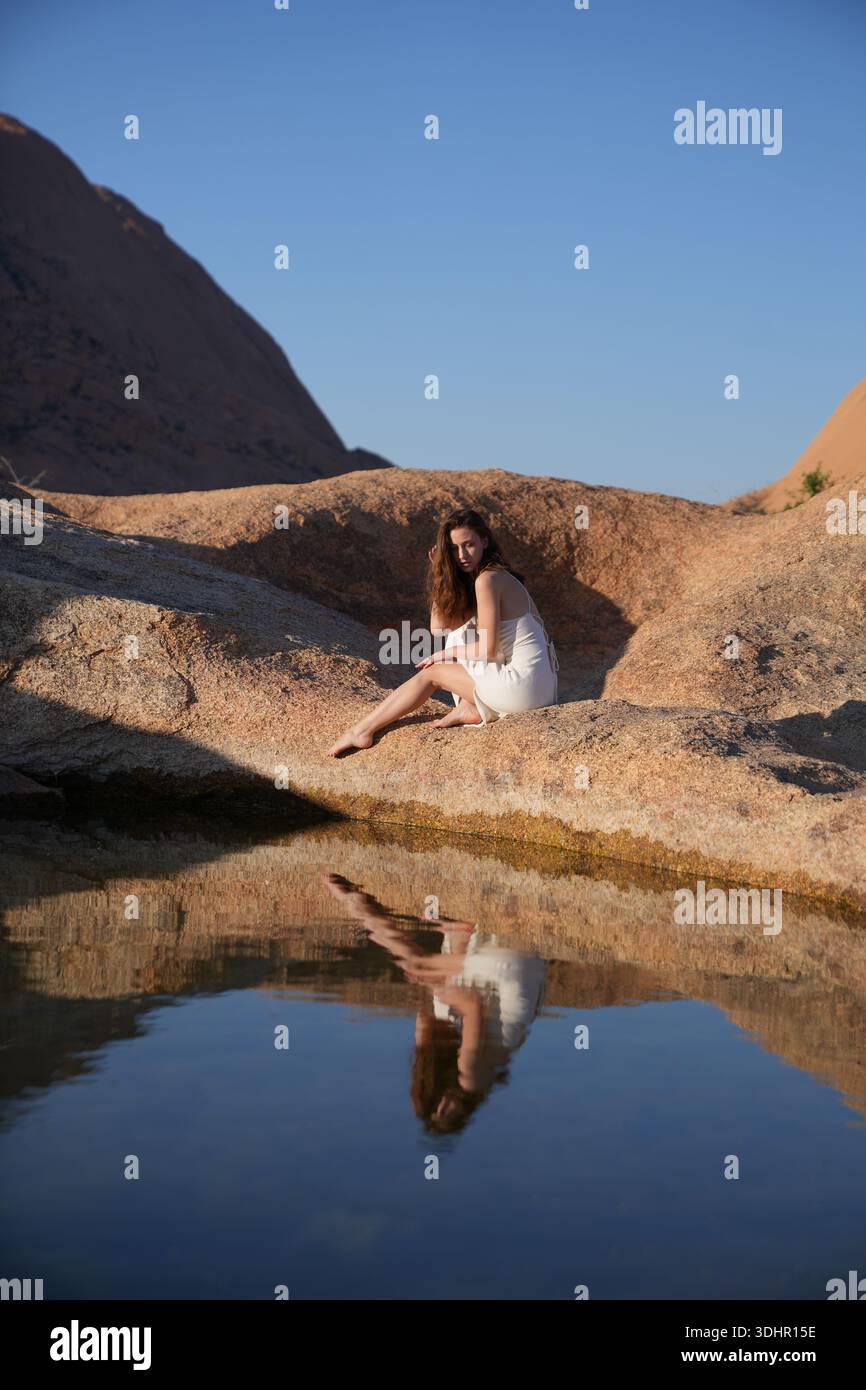 Jeunes femmes en robe blanche au lac de réflexion Banque D'Images