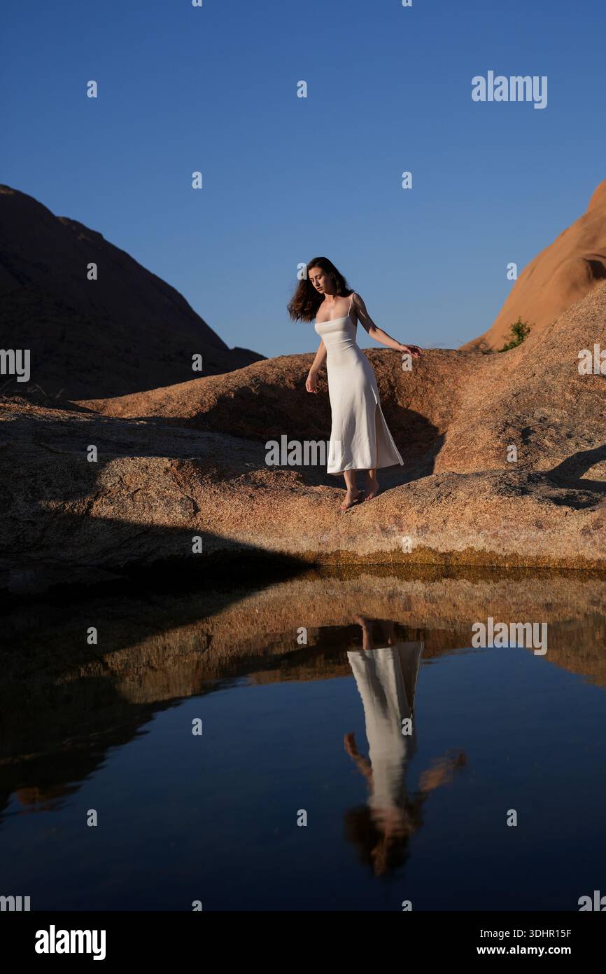 Jeunes femmes en robe blanche au lac de réflexion Banque D'Images