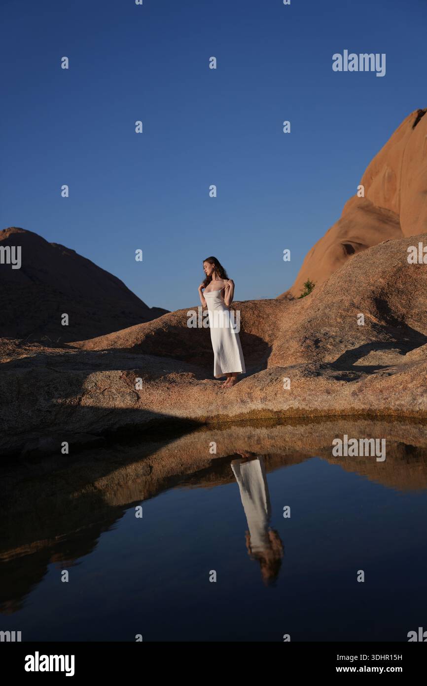 Jeunes femmes en robe blanche au lac de réflexion Banque D'Images